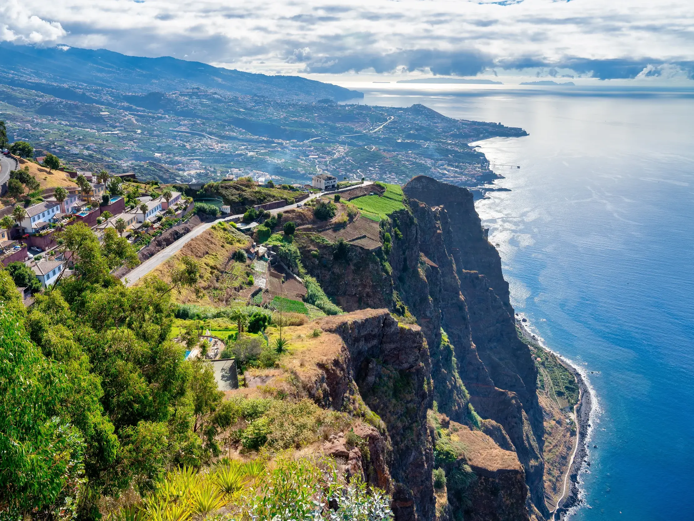 Beim Wandern auf Madeira eröffnet sich der Blick von der Steilküste über die grüne Küstenlandschaft und den Atlantik.