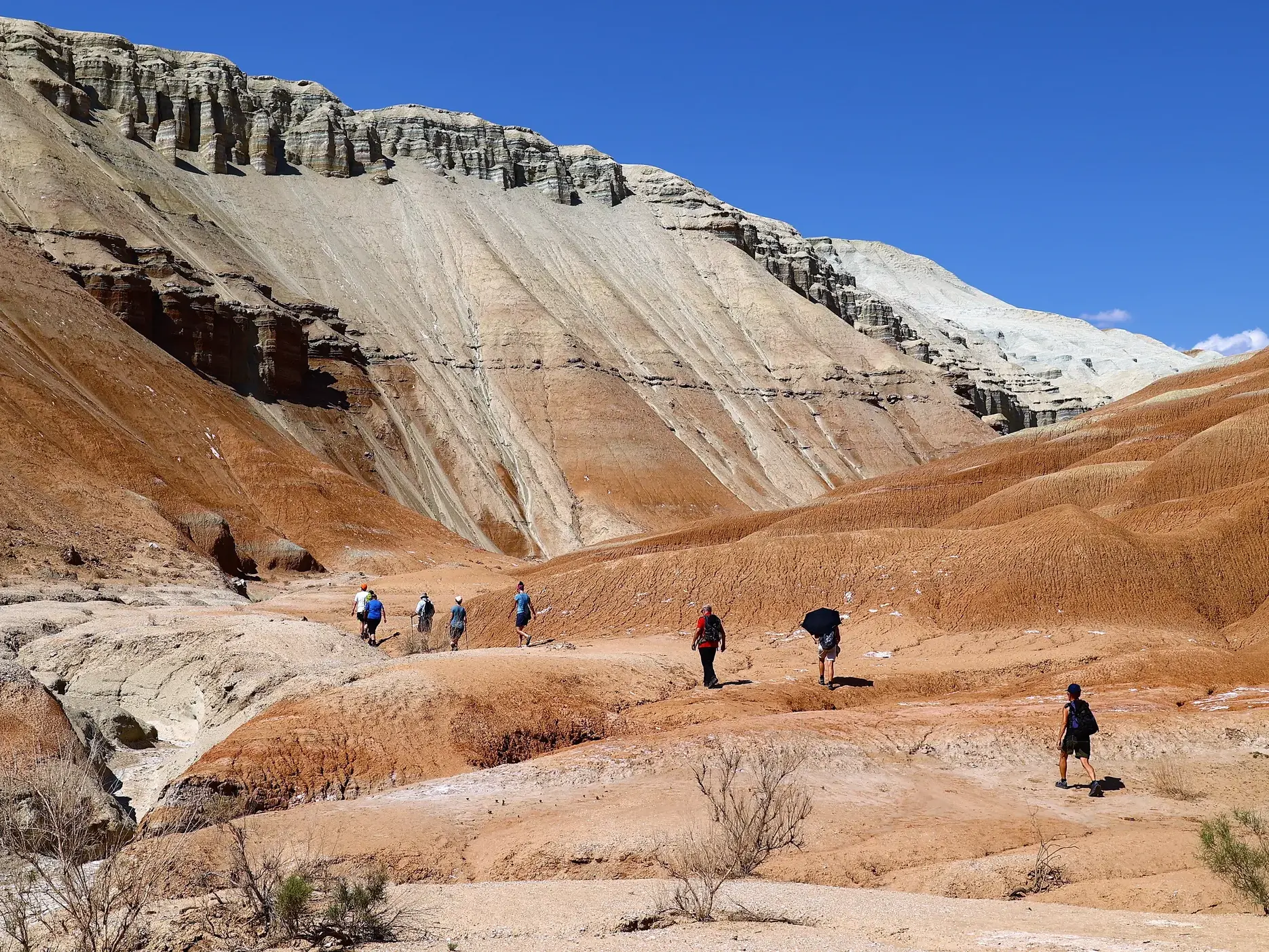 Eine Hauser-Reisegruppe beim Trekking durch die bunten Gesteinsschichten der Aktau-Berge im Altyn-Emel-Nationalpark.