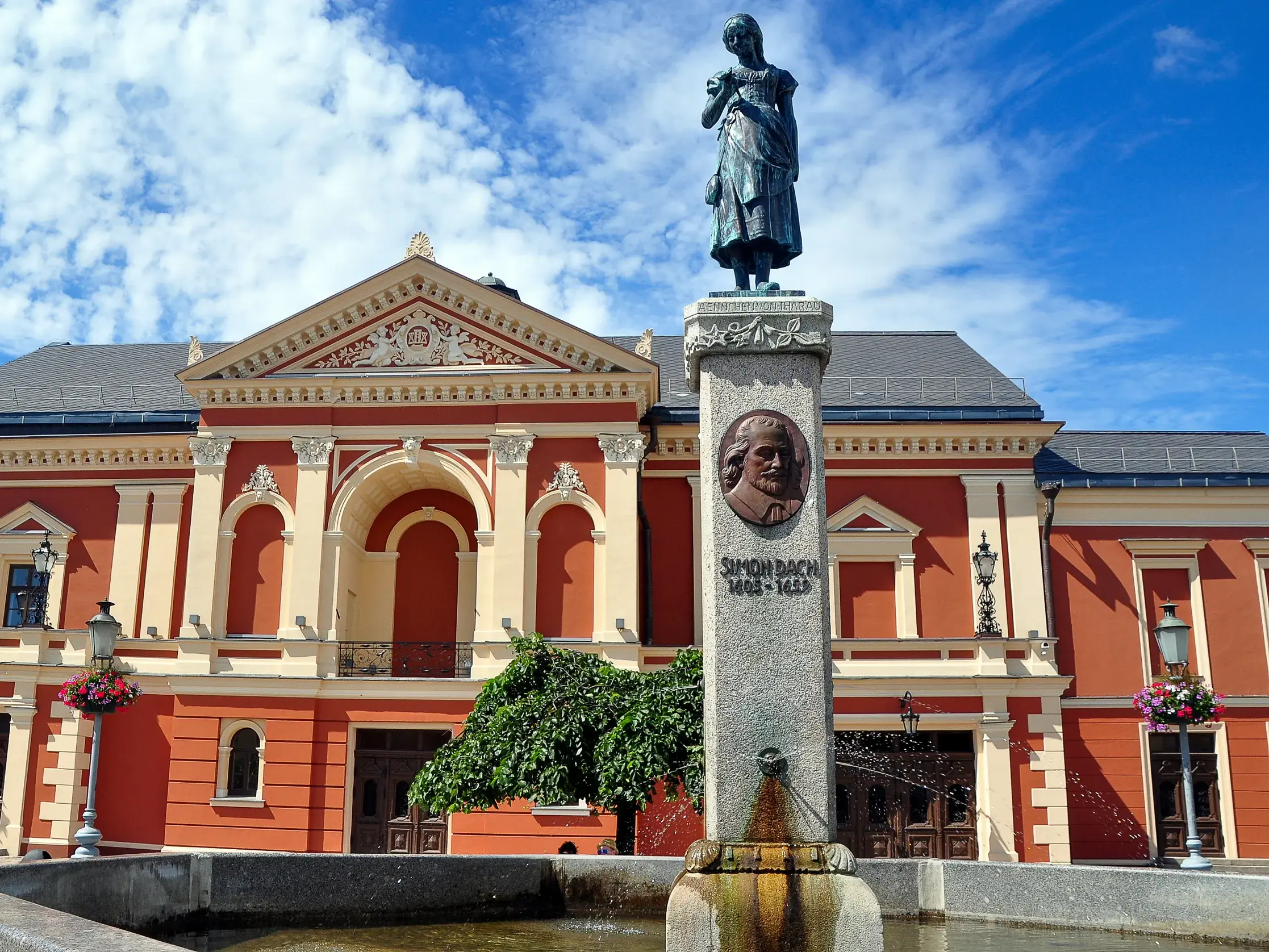 Der berühmte Ännchen-von-Tharau-Brunnen vor dem prachtvollen, roten Theatergebäude in der Altstadt von Klaipeda, Litauen.