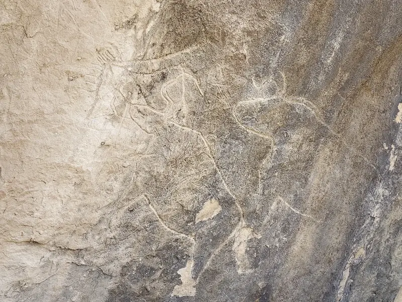 Felswand mit prähistorischen Gravuren von menschlichen Figuren und Tieren im UNESCO-Welterbe Qobustan, Aserbaidschan.