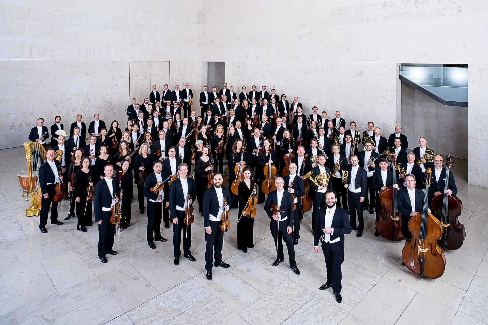Die Wiener Symphoniker mit ihren Instrumenten in festlicher Abendgarderobe vor einem Konzertauftritt.