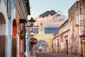 Der gelbe Uhrenbogen Arco de Santa Catalina in der Kolonialstadt Antigua mit Blick auf den majestätischen Vulkan de Agua.