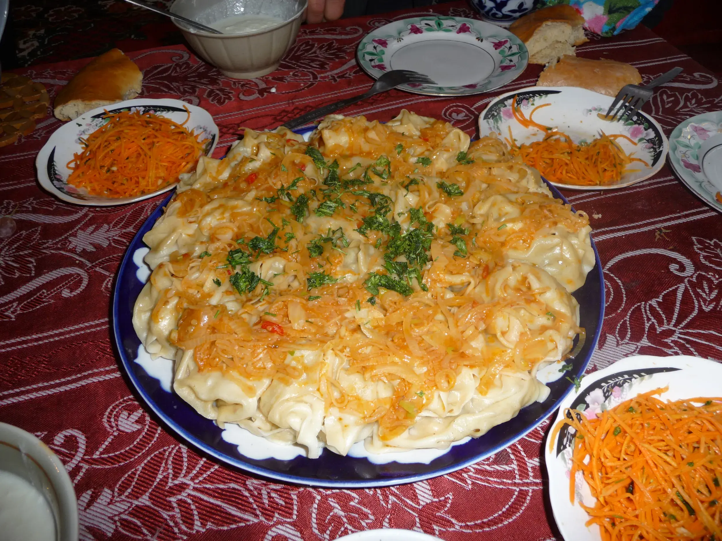 Eine große Platte mit Manti, traditionellen usbekischen Teigtaschen, bei einem gemeinsamen Essen während eines Homestays.