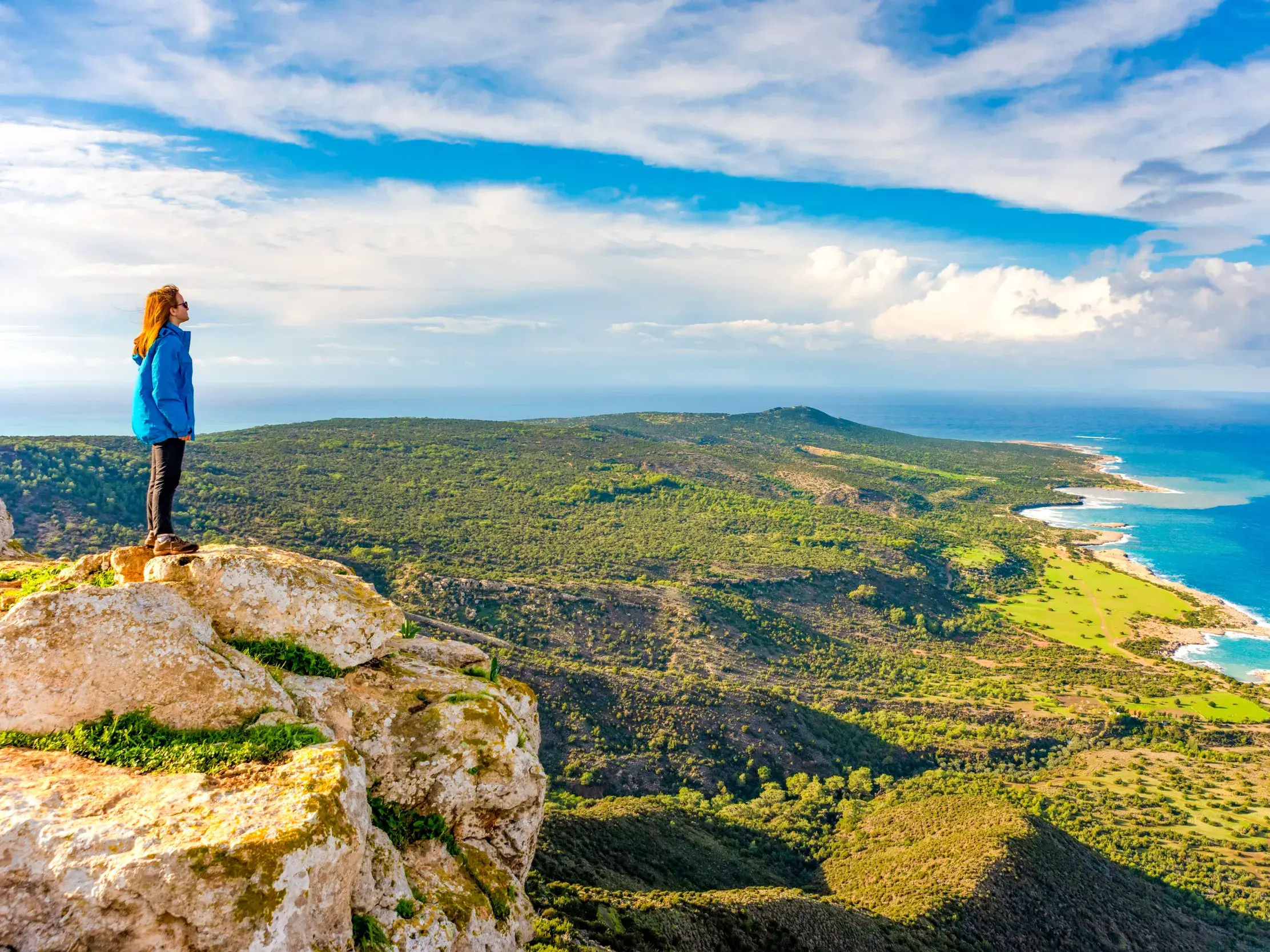 Wanderin steht auf einer Klippe auf dem Aphrodite-Trail und blickt über die Akamas-Halbinsel und die Chrysochous-Bucht.