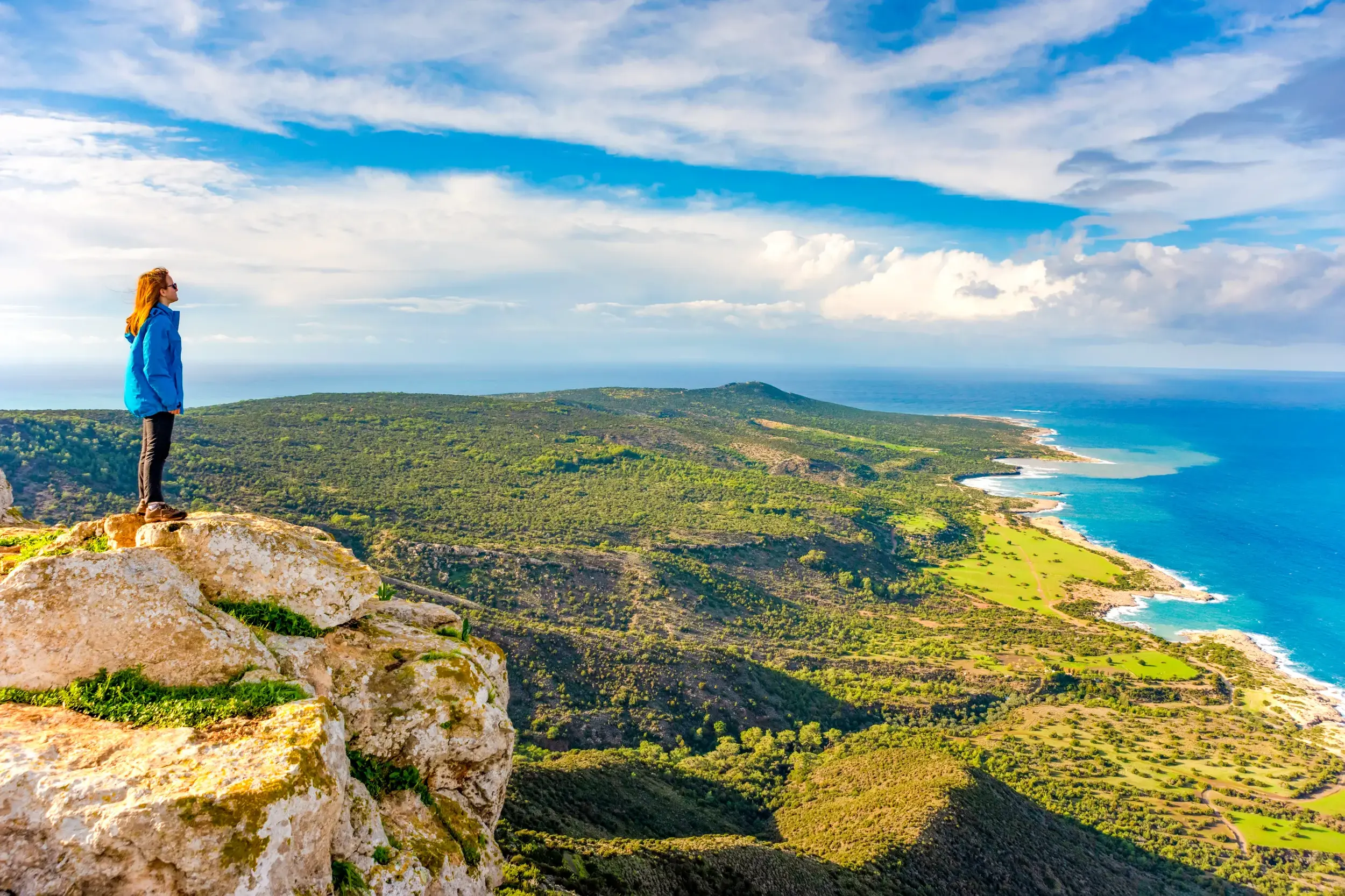 Wanderin steht auf einer Klippe auf dem Aphrodite-Trail und blickt über die Akamas-Halbinsel und die Chrysochous-Bucht.