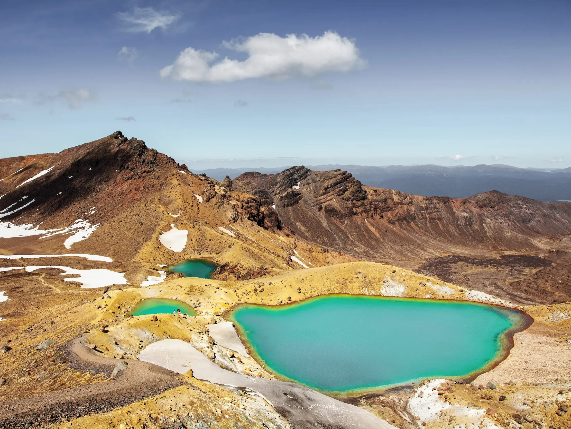 Wanderweg vorbei an den smaragdgrünen Seen in der kargen Vulkanlandschaft des Tongariro Alpine Crossing in Neuseeland.