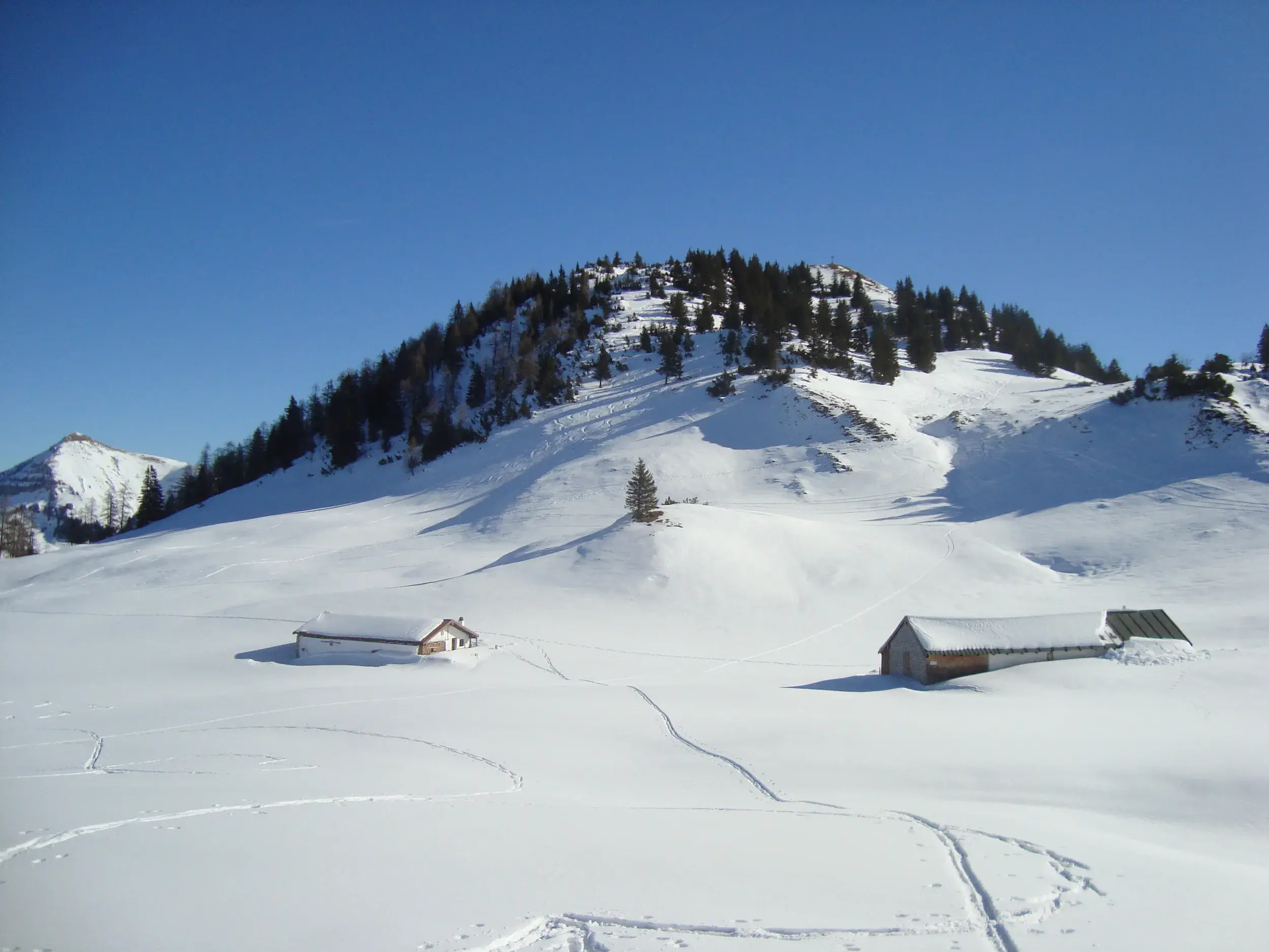Spuren einer Schneeschuhwanderung zur Rontalalm in einer tief verschneiten Winterlandschaft im Naturpark Karwendel.