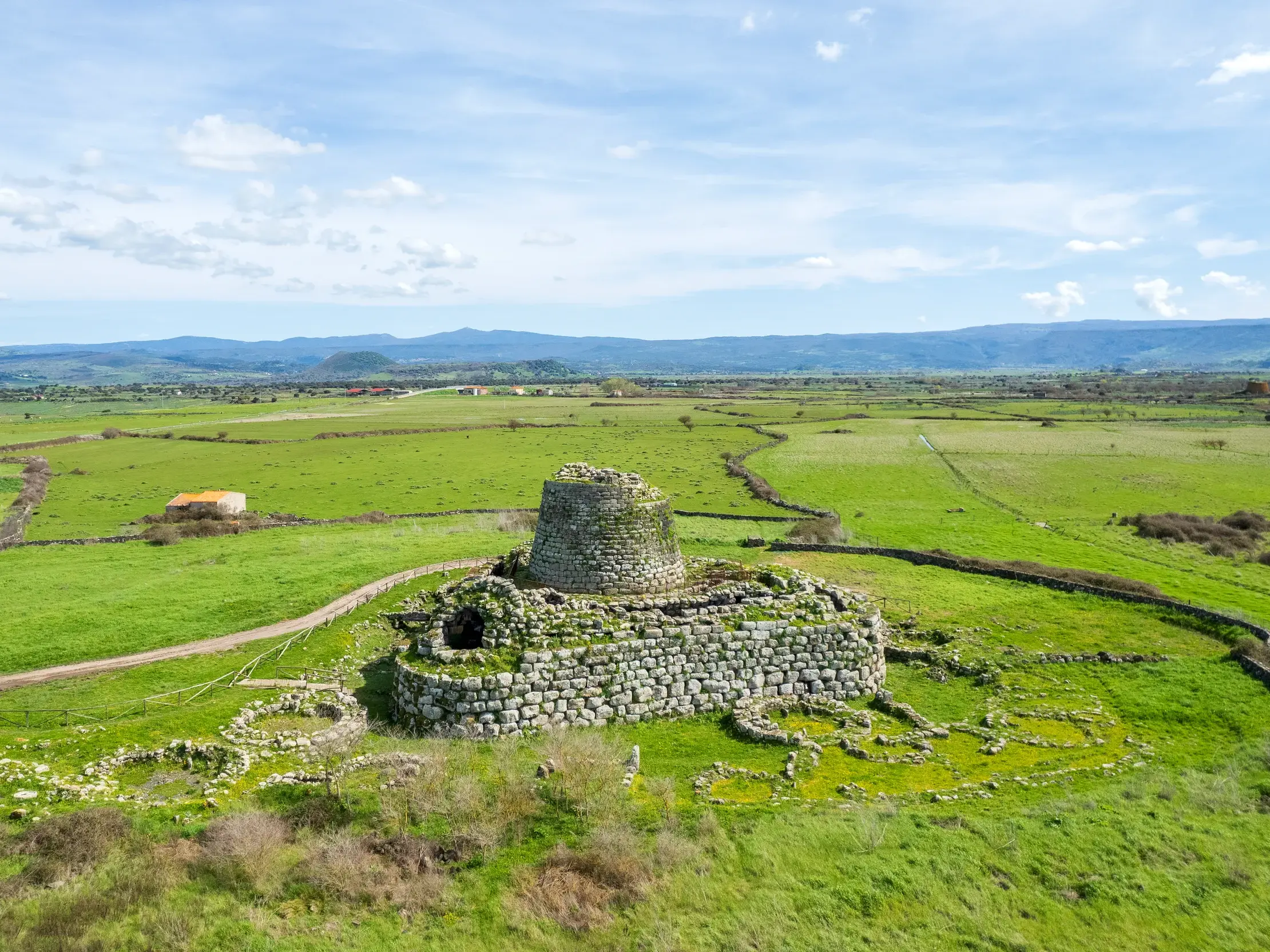 Der prähistorische Nuraghe Santu Antine in einer weiten, grünen Landschaft im Tal der Nuraghen auf Sardinien.