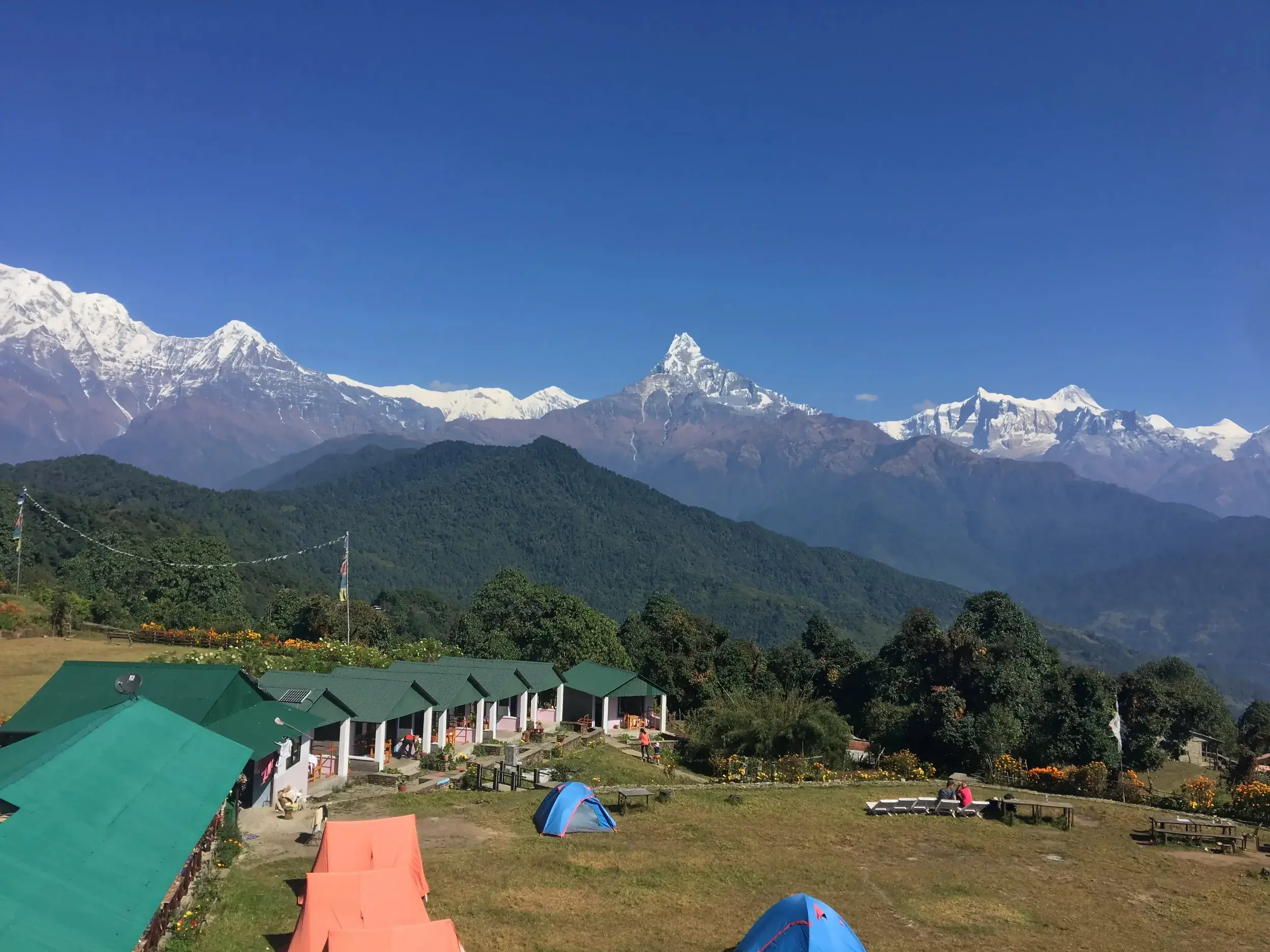 Weite Aussicht vom Australian Camp auf die schneebedeckten Gipfel des Annapurna-Massivs in Nepal bei klarem Himmel.