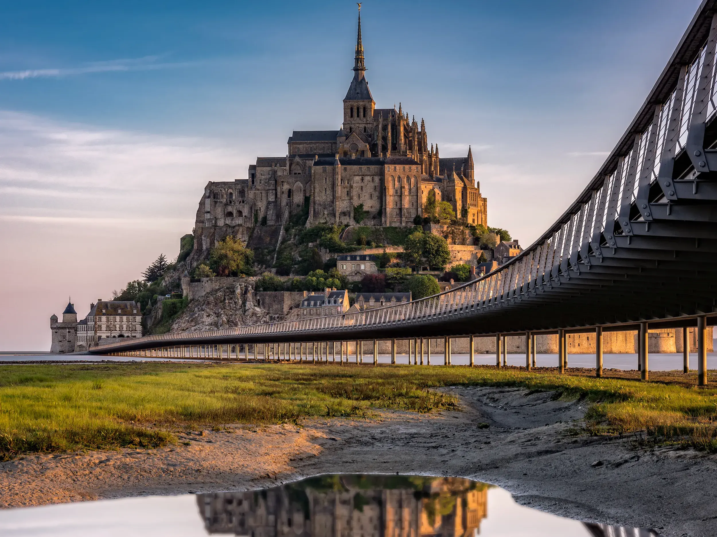 Der berühmte Klosterberg Mont St-Michel (UNESCO-Welterbe) in der Normandie ragt bei Abendstimmung aus dem Wattenmeer empor.