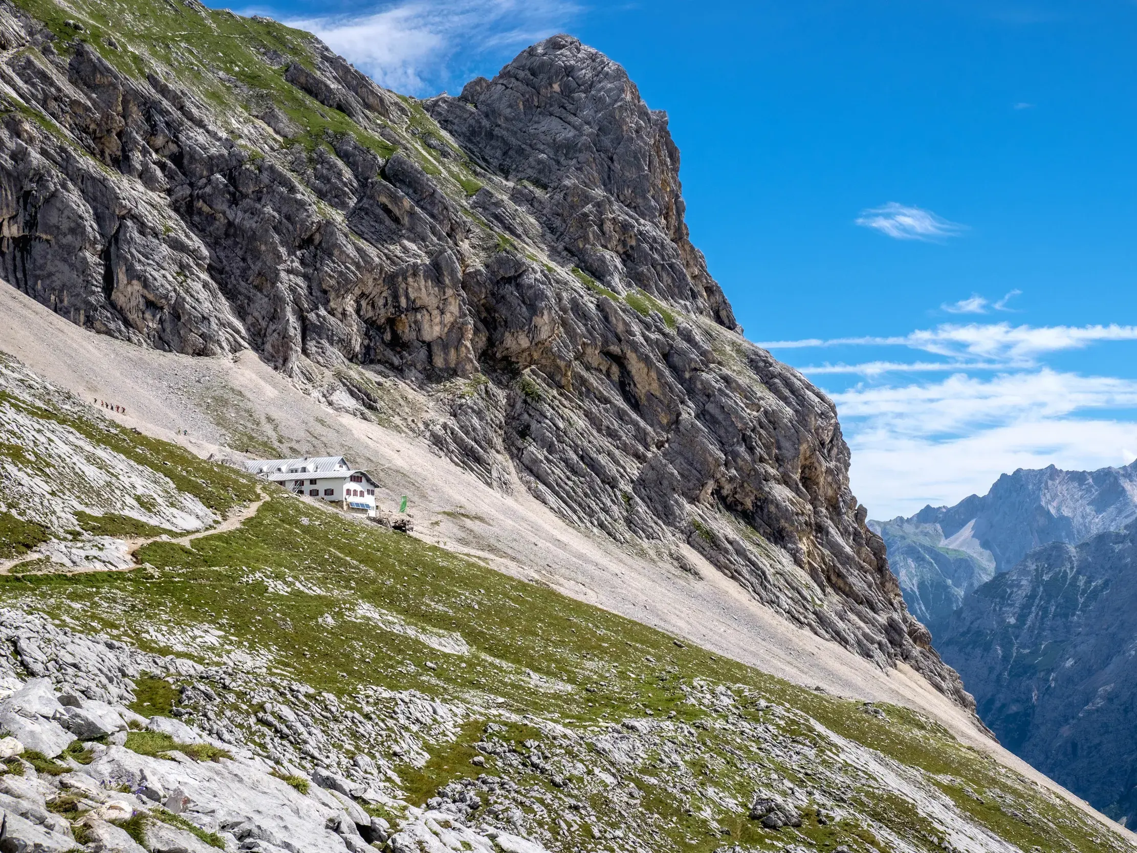 Die Knorrhütte auf der Alpenüberquerung, eingebettet in einen steilen Berghang im Wettersteingebirge bei Garmisch-Partenkirchen.