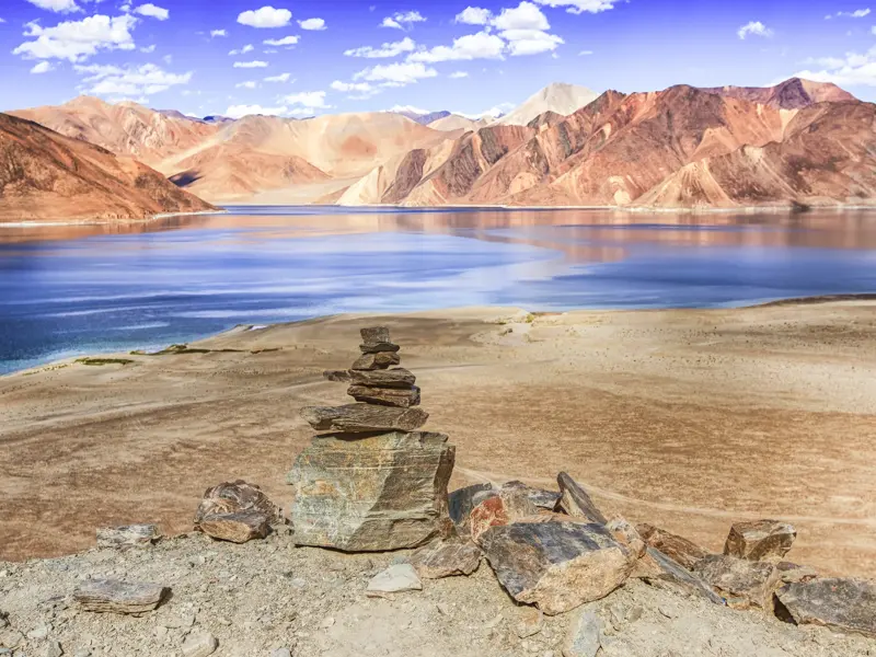 Steinmännchen am Pangong-See auf einer Trekking-Tour durch die karge Berglandschaft von Ladakh im Himalaya.