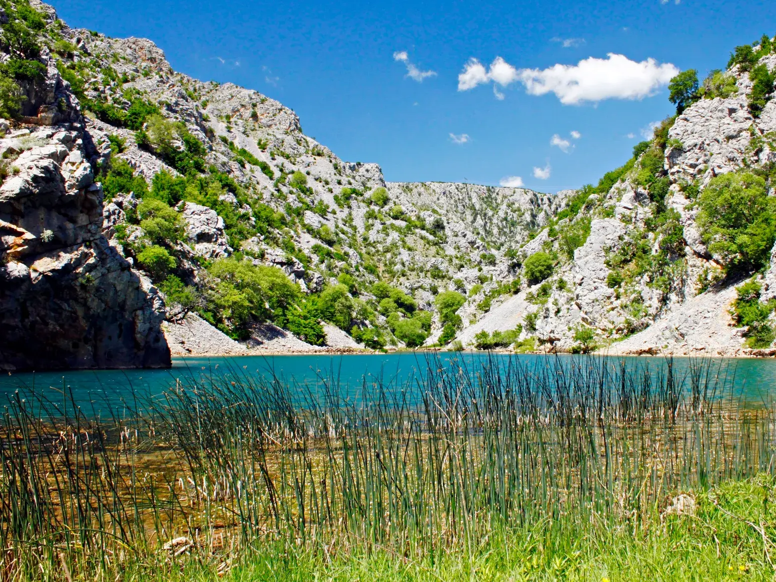Smaragdgrüner Zrmanja-Fluss in einer tiefen Felsenschlucht in Kroatien, ein Naturhighlight auf der Trekkingreise.