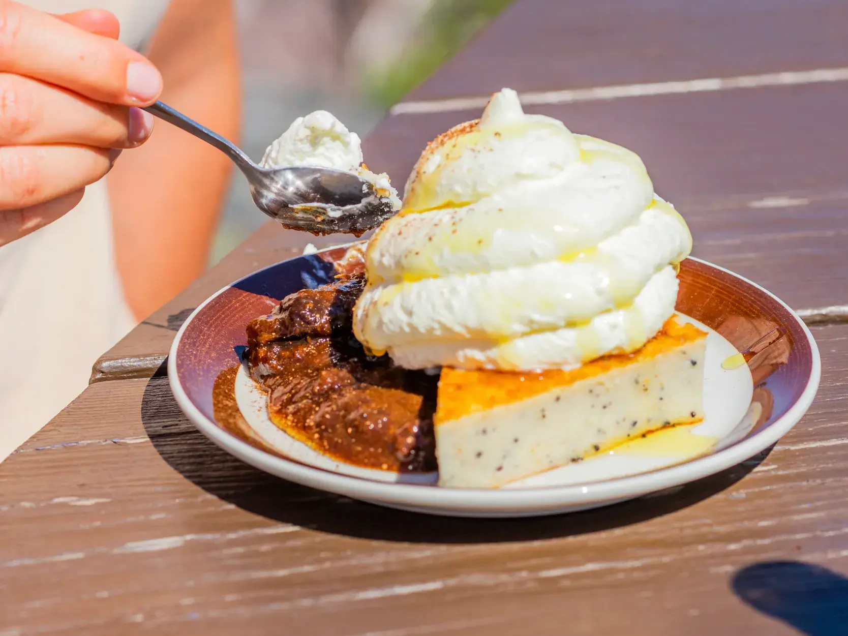Eine Person genießt auf den Alandinseln einen typischen Aland-Pfannkuchen mit Pflaumenmus und Sahne.