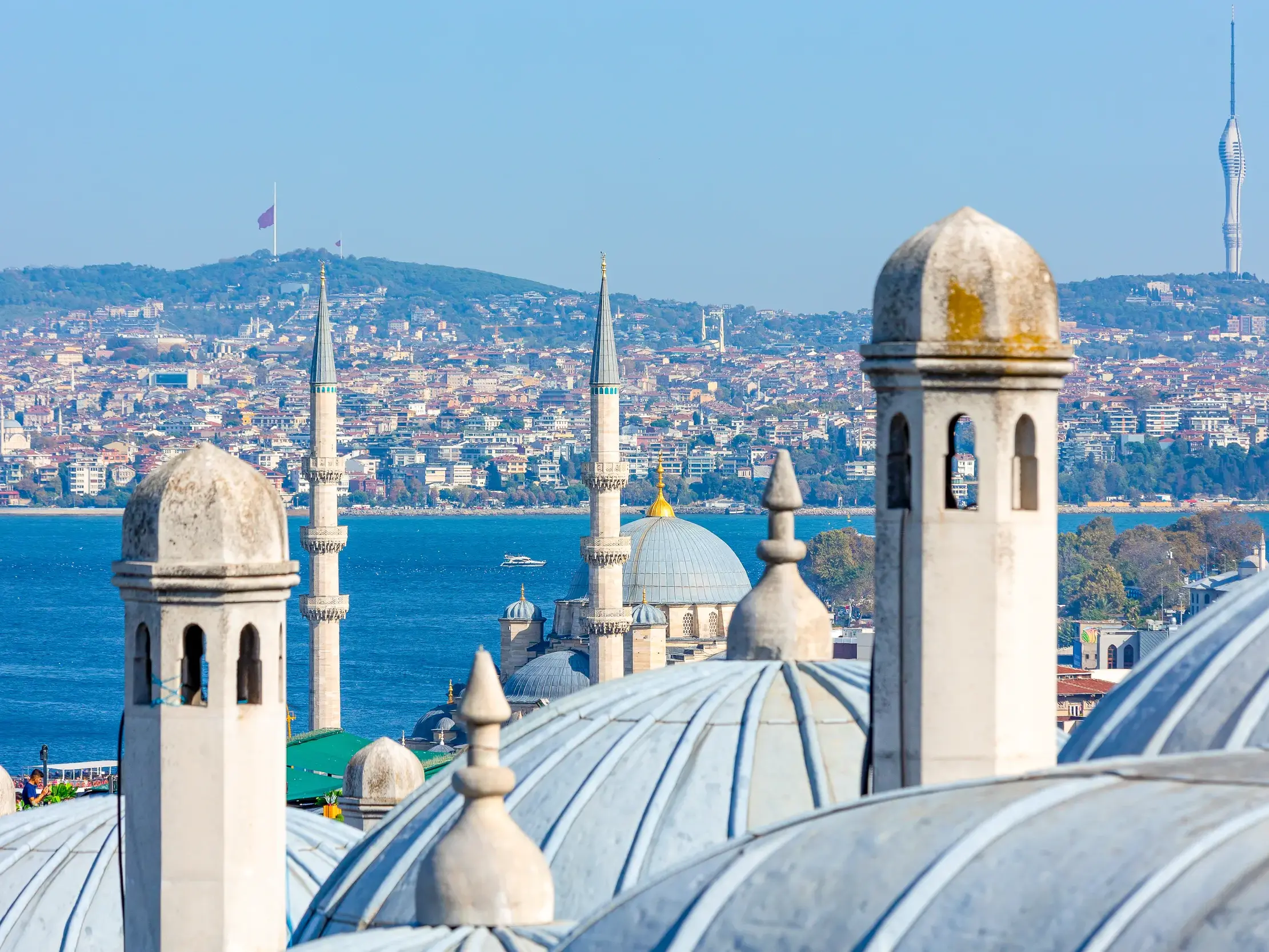 Blick von der Süleymaniye-Moschee über die Dächer und Minarette auf den blauen Bosporus und die Skyline von Istanbul.