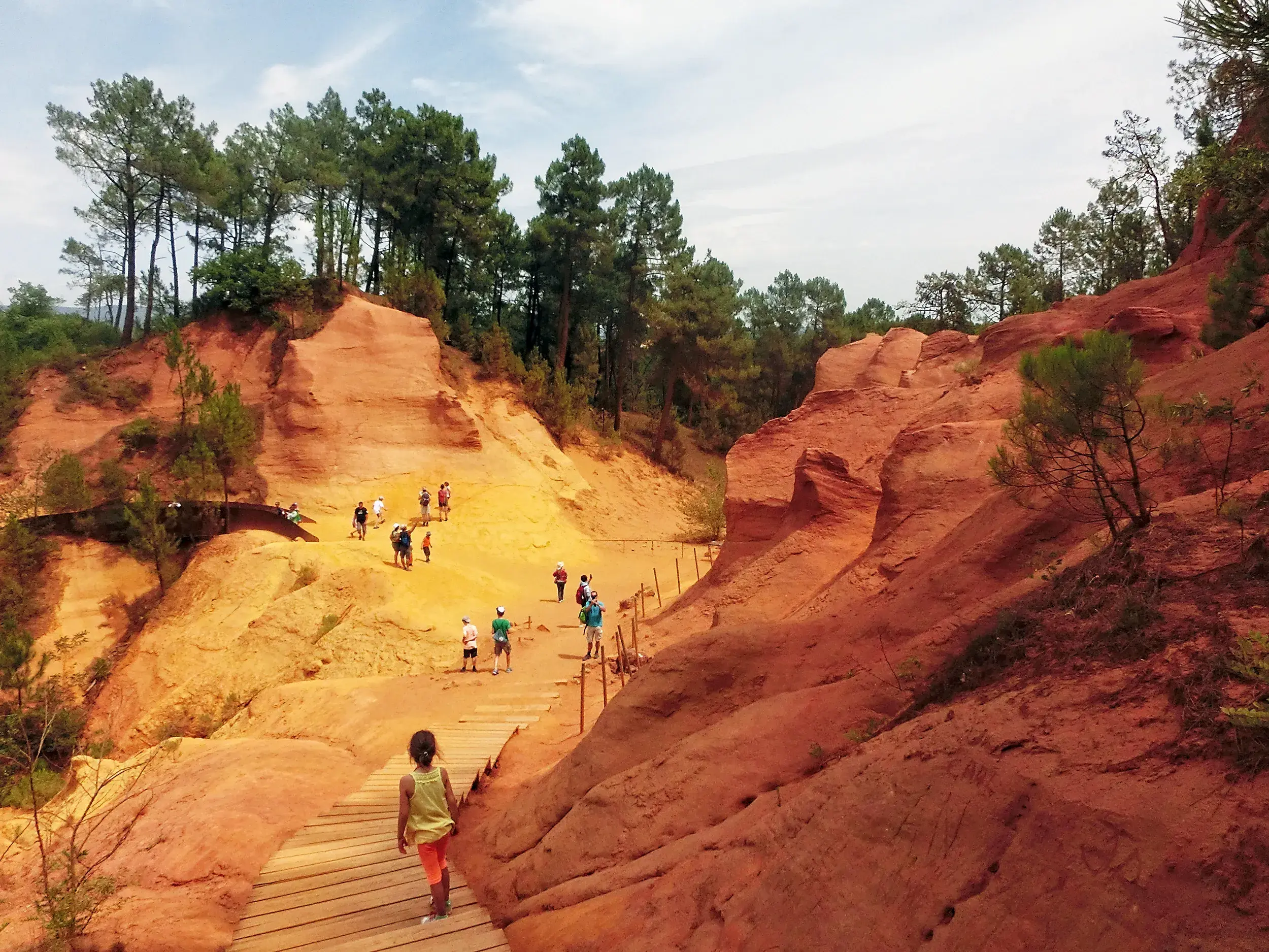 Reisegruppe erkundet die leuchtend roten Ockerfelsen von Roussillon im Naturpark Luberon in der Provence.