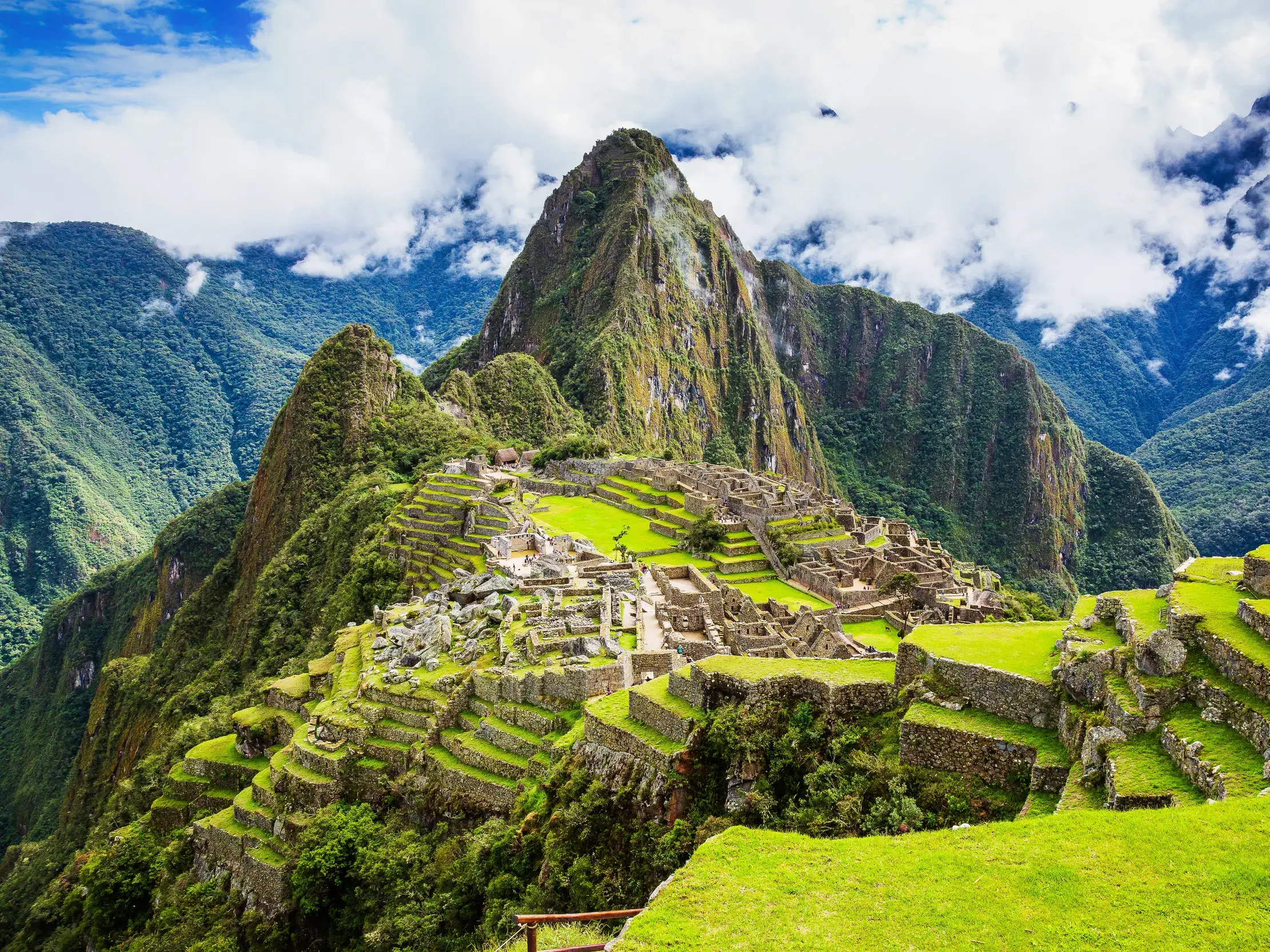 Blick vom Sonnentor Inti Punku auf die weltberühmte Inkastätte Machu Picchu mit ihren grünen Terrassen in den peruanischen Anden.