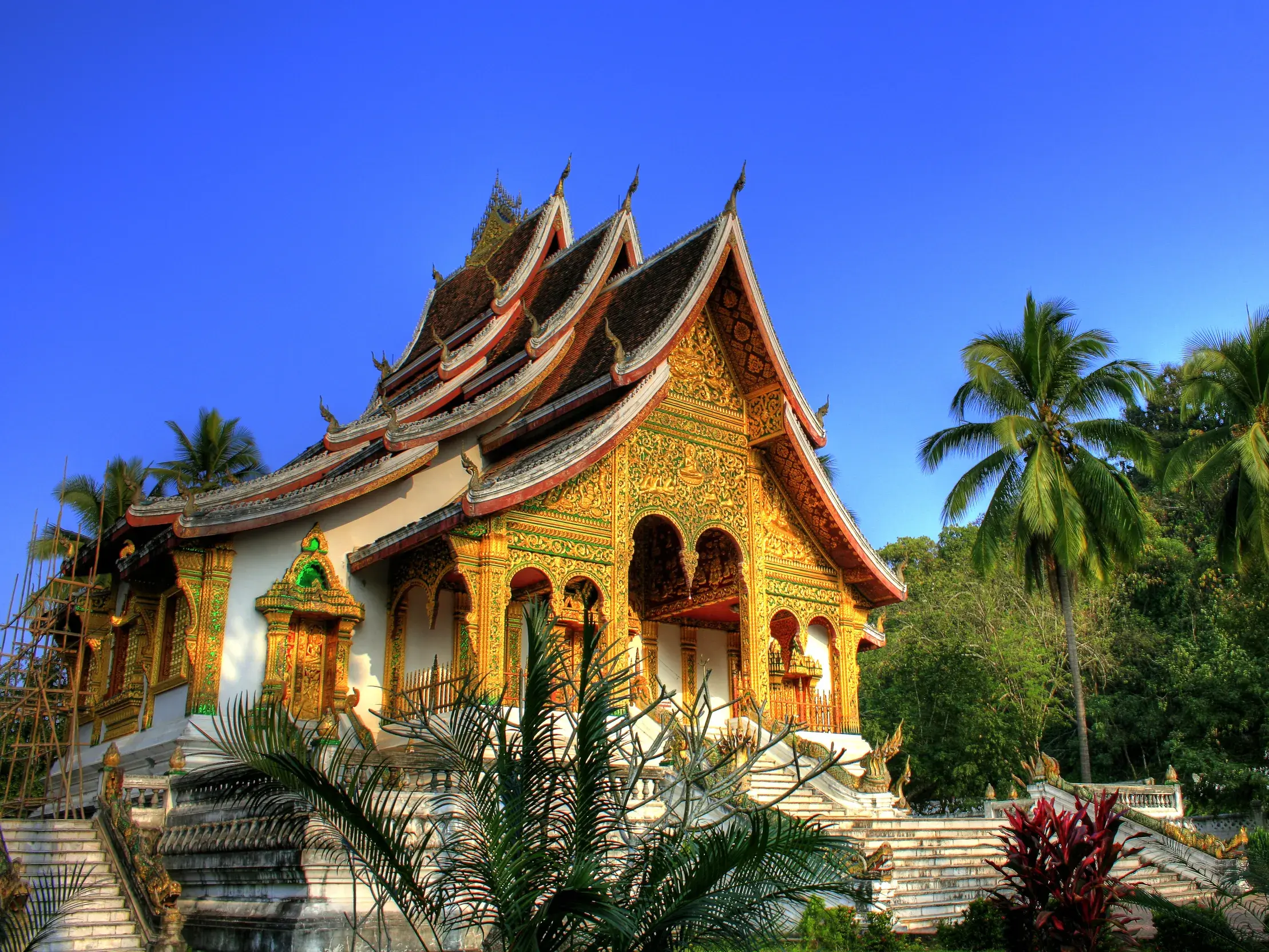 Kulturelles Highlight in Laos: der goldene Tempel Haw Pha Bang im Königspalast von Luang Prabang bei strahlendem Sonnenschein.