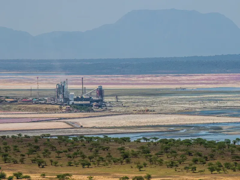 Blick vom Nguruman Escarpment auf den bunten Lake Magadi mit einer Anlage zur Soda-Gewinnung im Afrikanischen Grabenbruch.