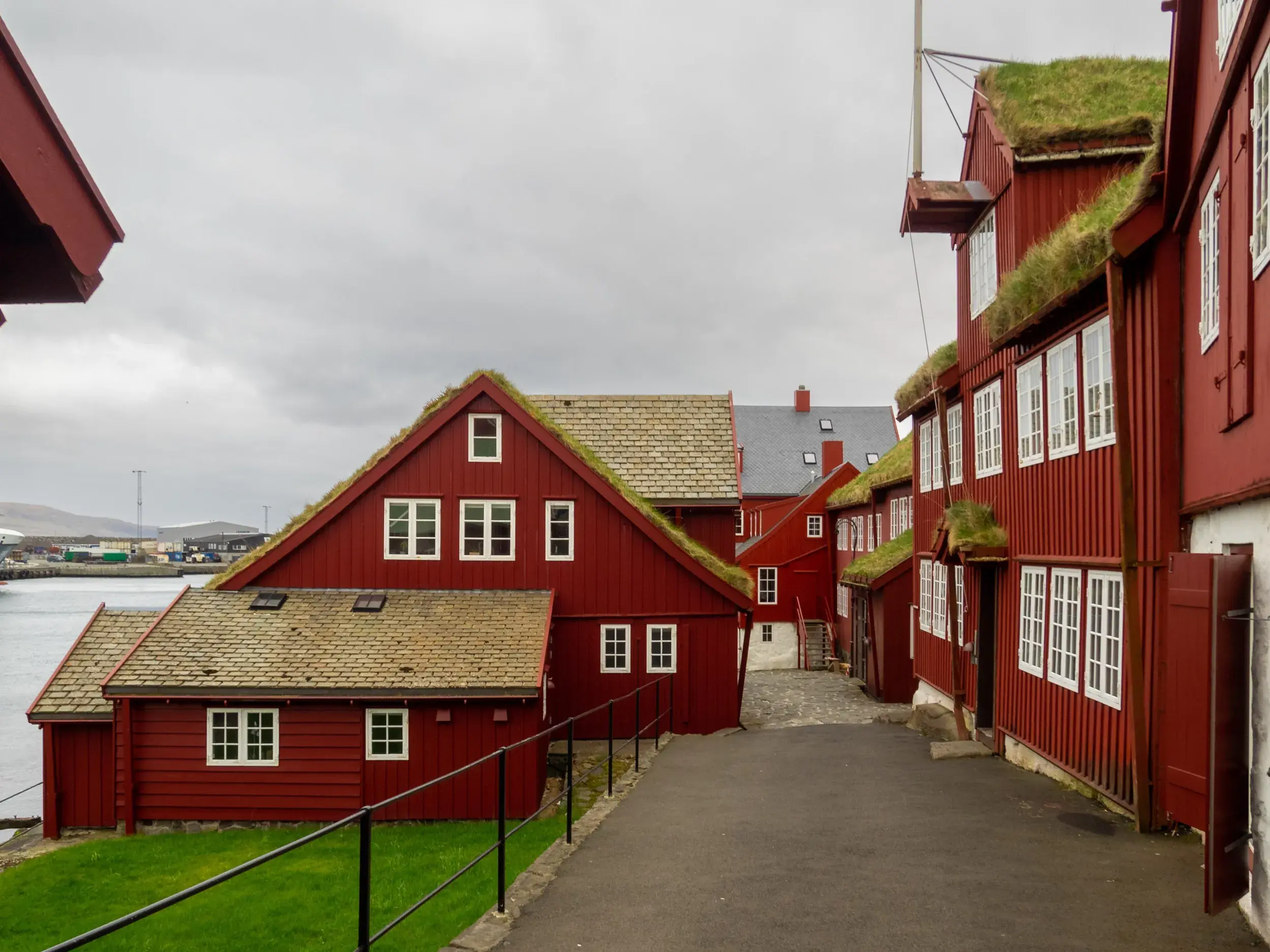 Traditionelle rote Holzhäuser mit Grasdächern im historischen Viertel Tinganes in Tórshavn auf den Färöer-Inseln.