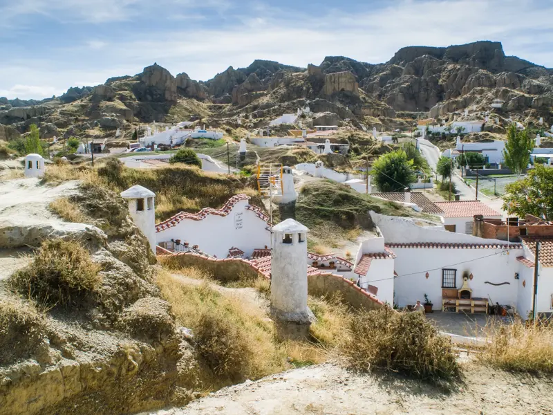 Die in den Sandstein gegrabenen, weißen Höhlenwohnungen von Guadix in Andalusien mit ihren markanten, weißen Schornsteinen.
