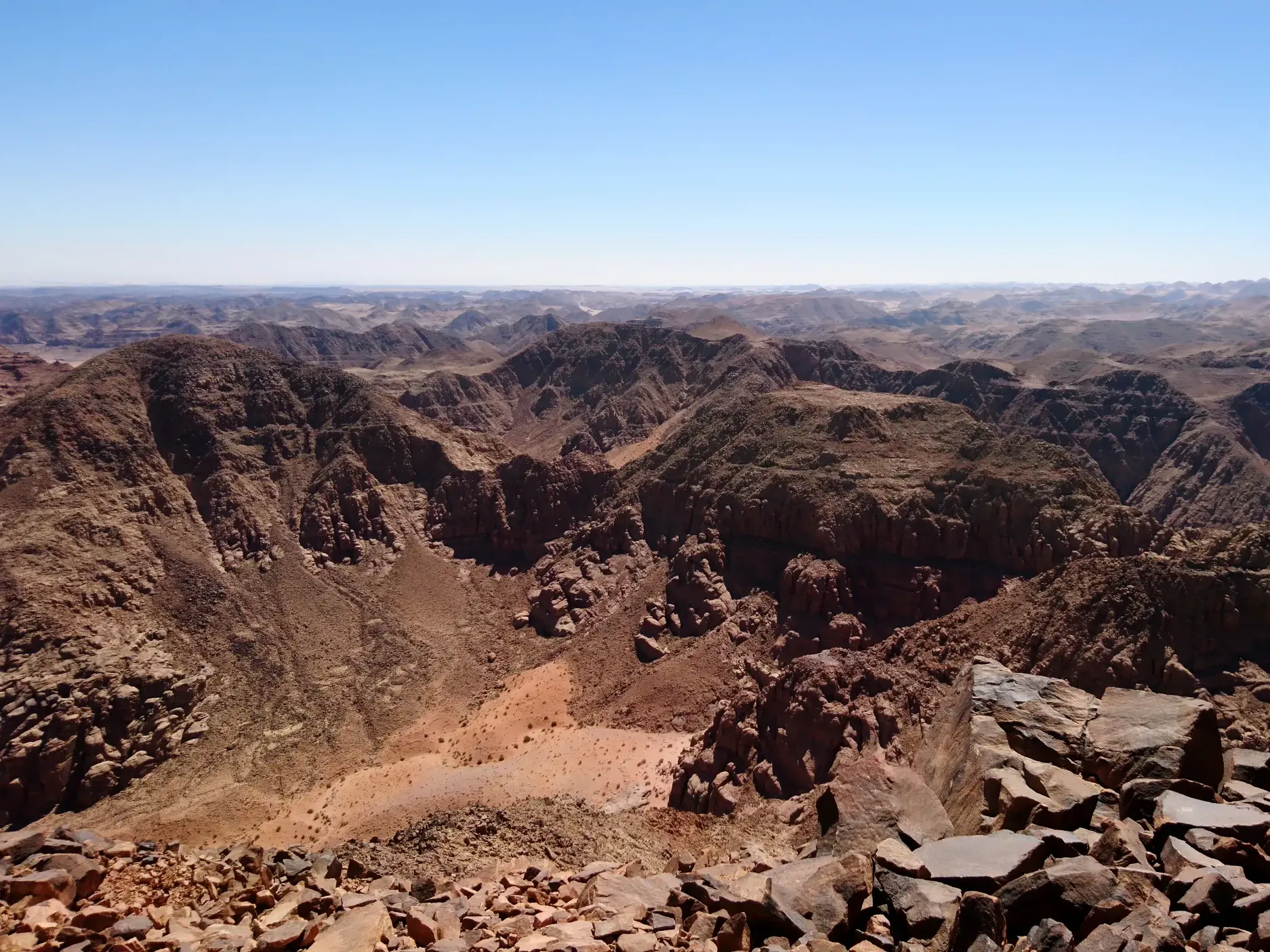 Panoramablick vom felsigen Gipfel des Dschabal Umm ad-Dami über die unendliche Weite der Wüstenlandschaft von Wadi Rum.