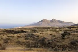 Ausblick über die steppenartige Vulkanlandschaft des Naturparks Cabo de Gata mit dem Mittelmeer und Küstengebirge.