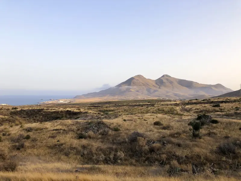 Ausblick über die steppenartige Vulkanlandschaft des Naturparks Cabo de Gata mit dem Mittelmeer und Küstengebirge.
