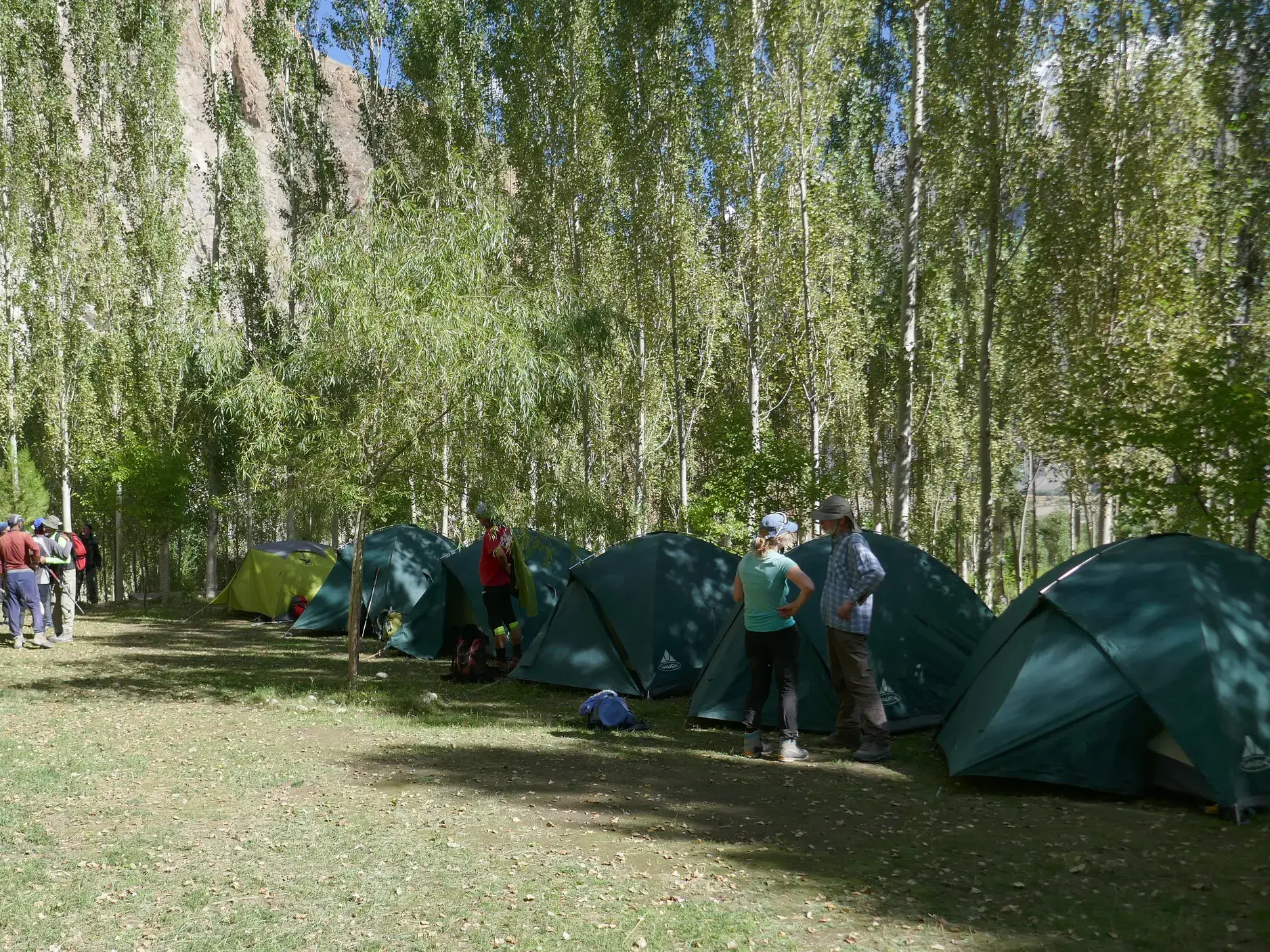 Wanderer einer Reisegruppe im Zeltlager Camp Paiju, einer grünen Oase auf der Trekkingreise zum K2 in Pakistan.