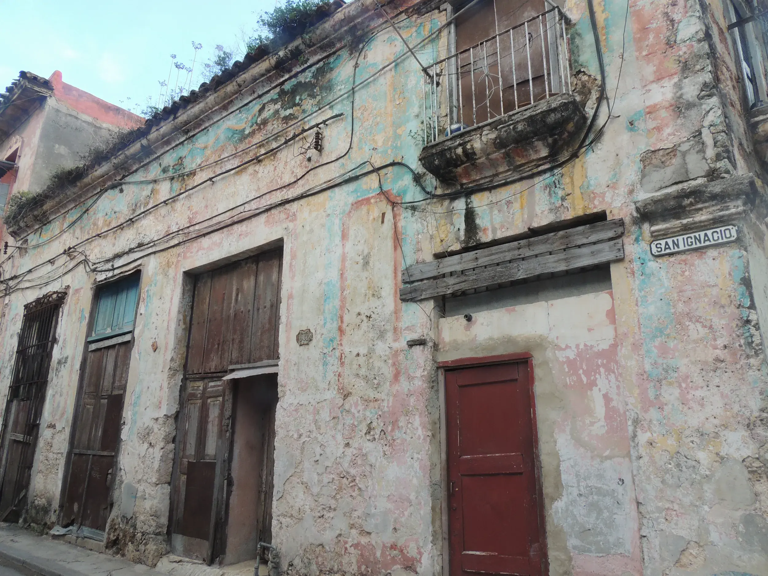 Verwitterte, farbenfrohe Fassade eines Kolonialgebäudes in der Calle San Ignacio in der Altstadt von Havanna, Kuba.