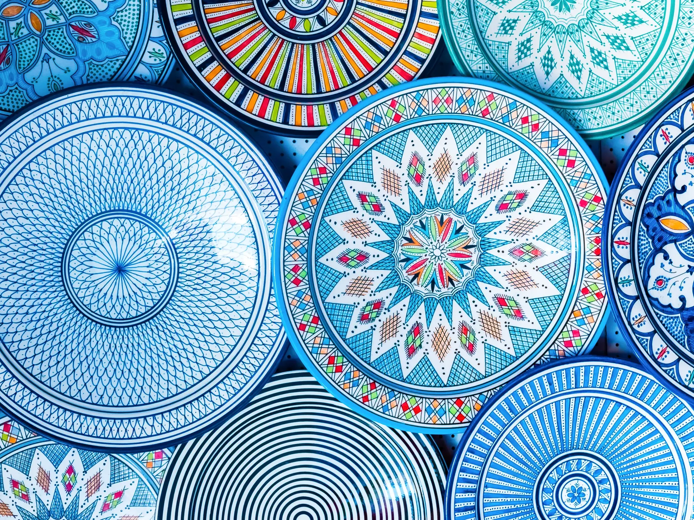 Nahaufnahme von bunten, handbemalten Keramiktellern mit filigranen orientalischen Mustern, typisches Kunsthandwerk in Kairo.