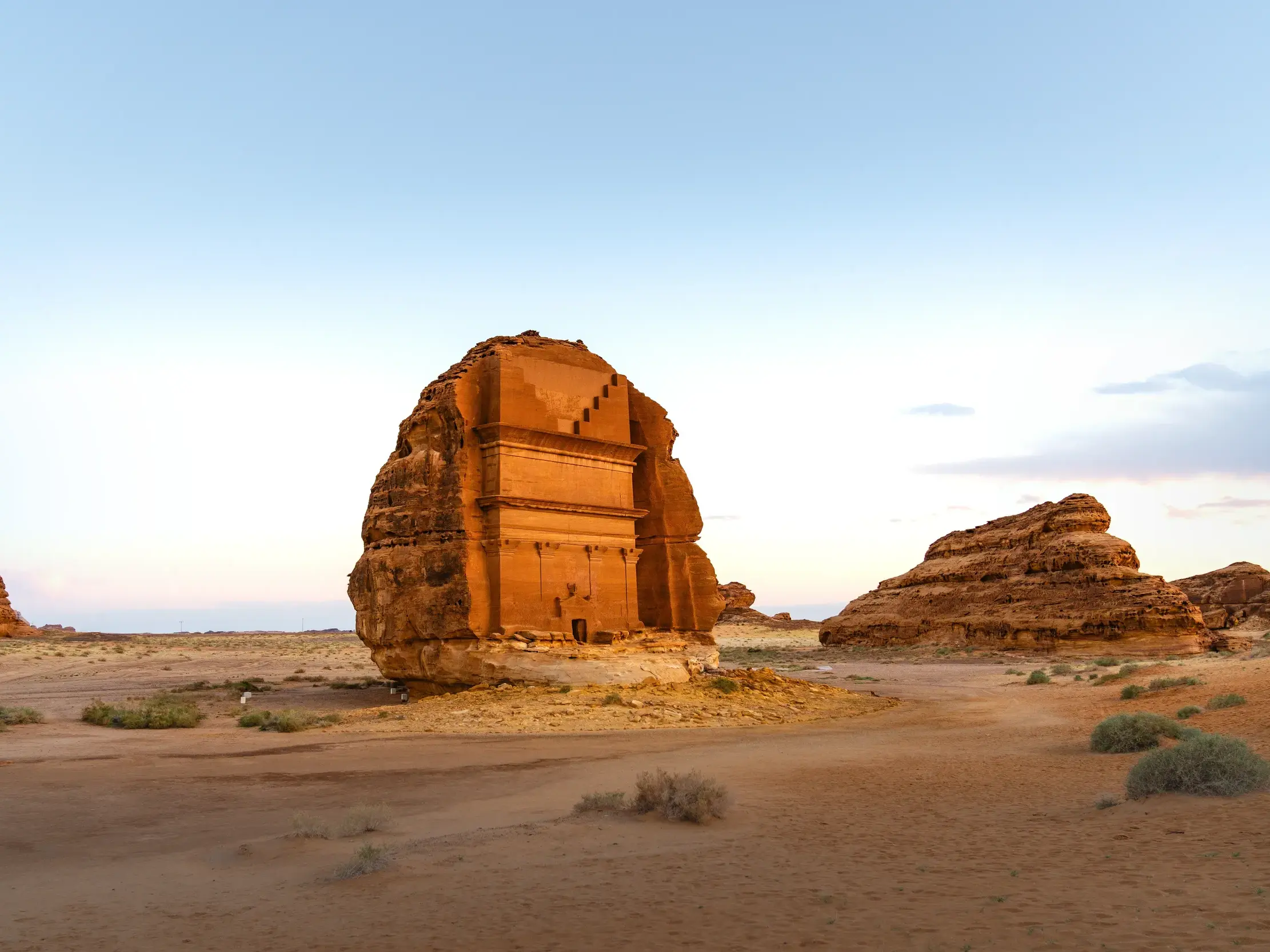 Das monumentale Nabatäer-Felsengrab Qasr al-Farid im UNESCO-Welterbe Hegra in der Wüste von Saudi-Arabien im Abendlicht.