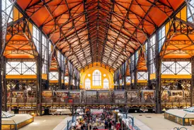 Blick von der Empore auf das rege Markttreiben in der Großen Markthalle in Budapest mit ihrer eindrucksvollen Stahlkonstruktion.