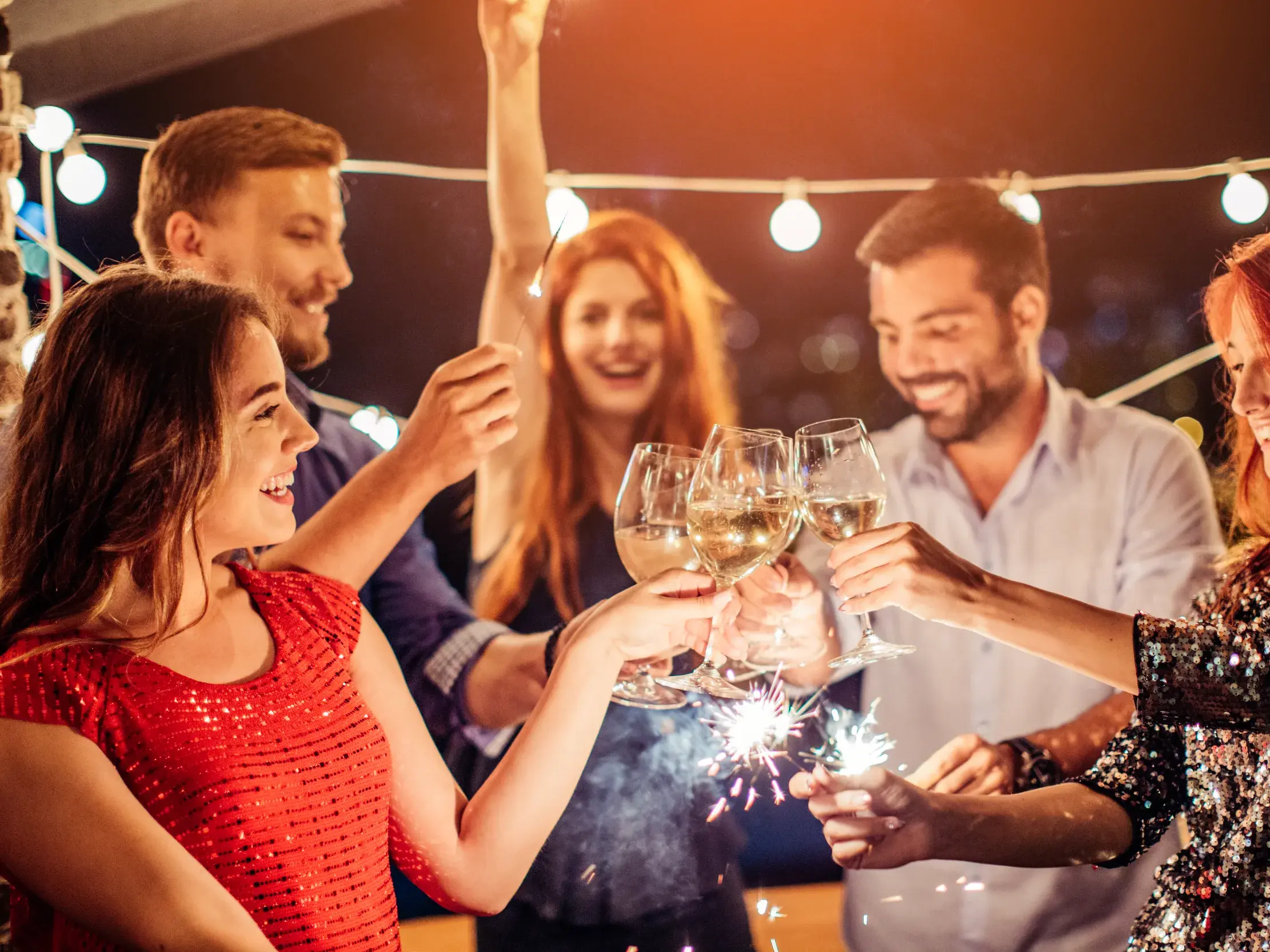 Gruppe von Singles und Alleinreisenden stößt zu Silvester mit Wein und Wunderkerzen über den Dächern von Istanbul an.