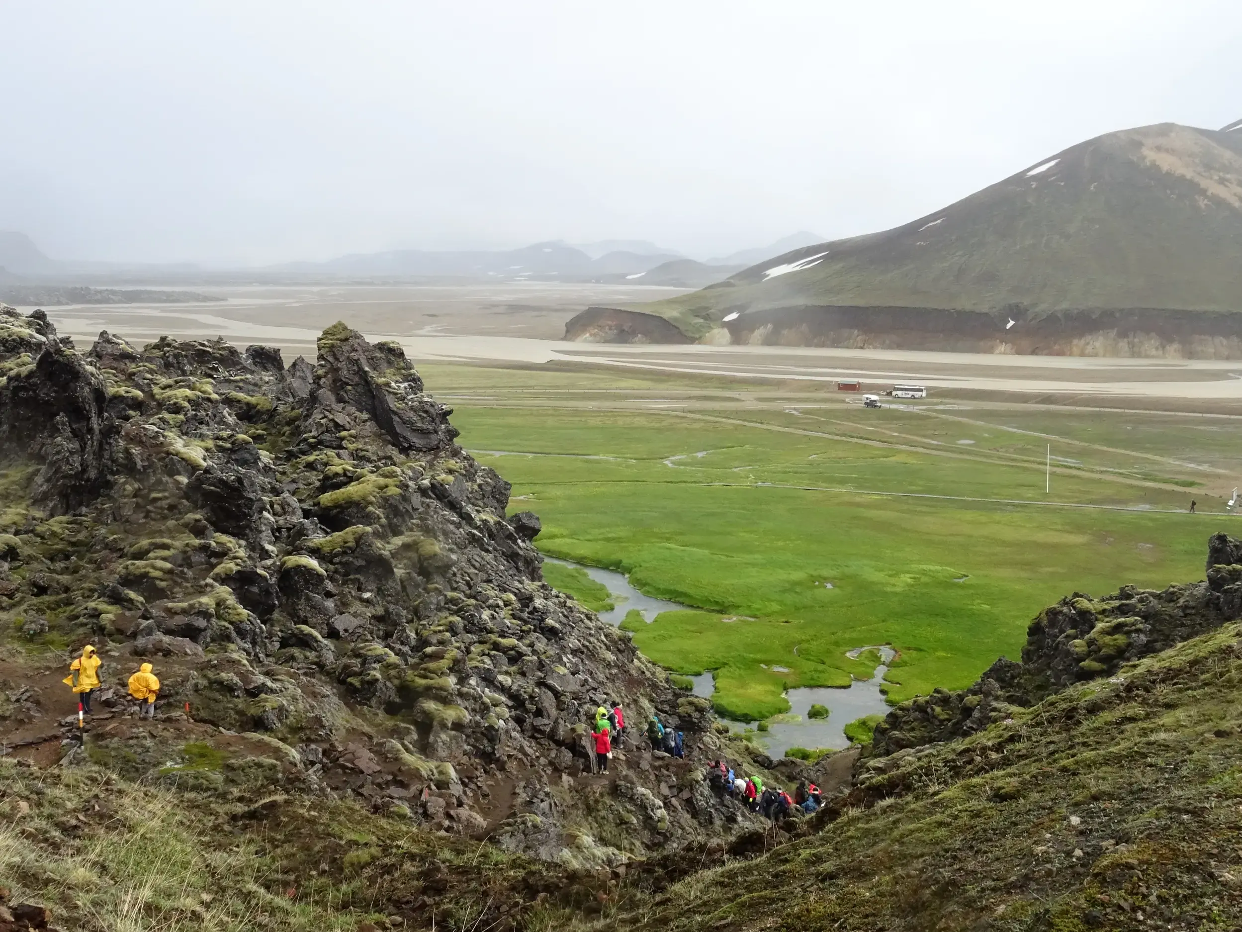 Eine Hauser-Gruppenreise wandert durch die moosbedeckte Eldgiá-Schlucht mit Blick auf das weite Tal in Islands Hochland.