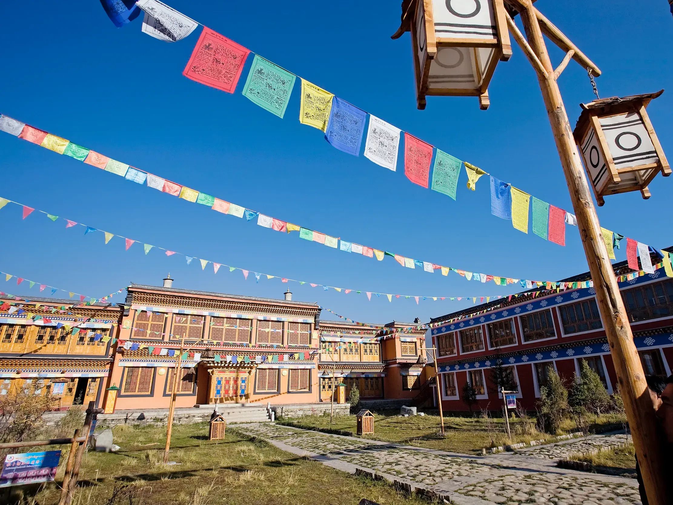 Bunte Gebetsfahnen wehen über dem traditionellen Samye-Kloster in Tibet unter einem strahlend blauen Himmel.