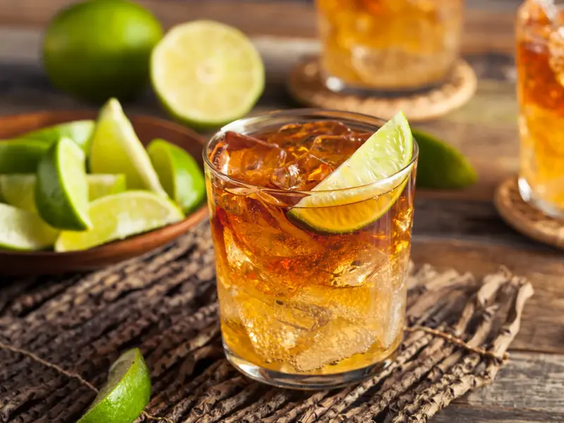 Glas mit traditionellem Rhum Arrangé, Eiswürfeln und Limettenspalte, typisch für eine kulinarische Pause auf La Réunion.