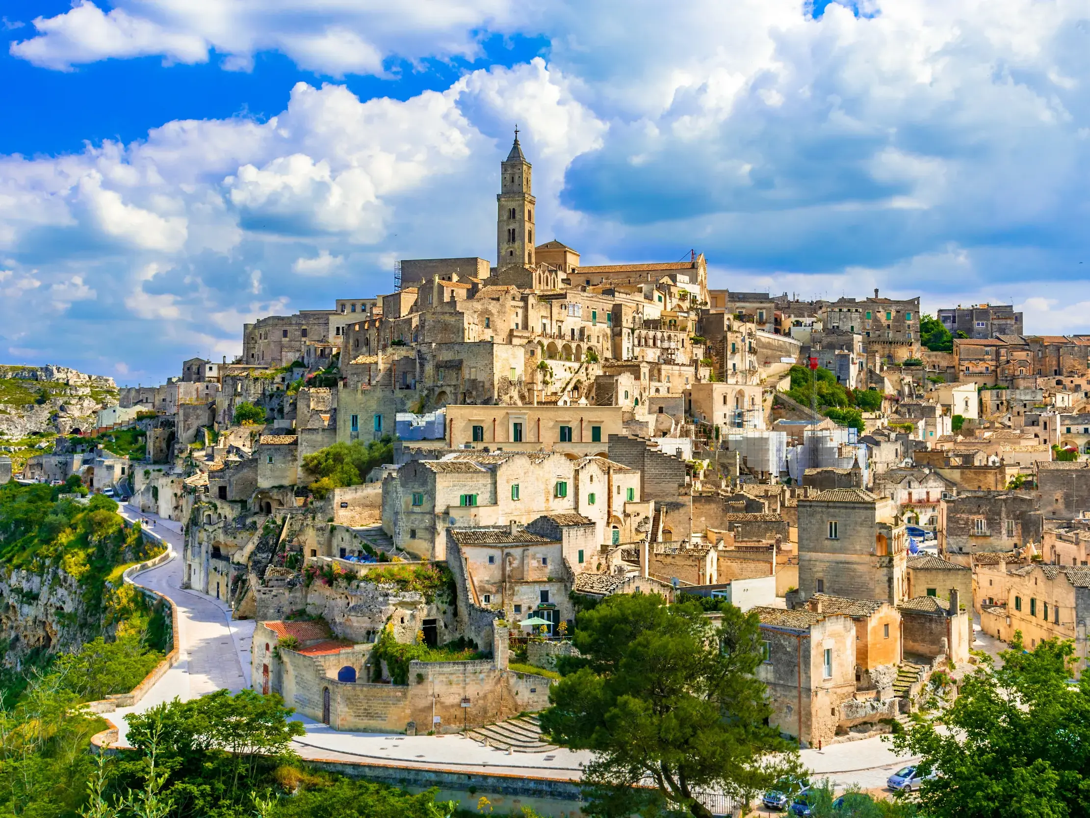 Panoramablick auf die Felsenstadt Matera mit den historischen Höhlenwohnungen der Sassi an einem sonnigen Tag in Italien.