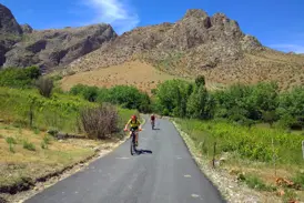 Zwei Radfahrer auf einer Hauser Radreise durch die hügelige Landschaft des Chatkal-Gebirges bei Parkent in Usbekistan.