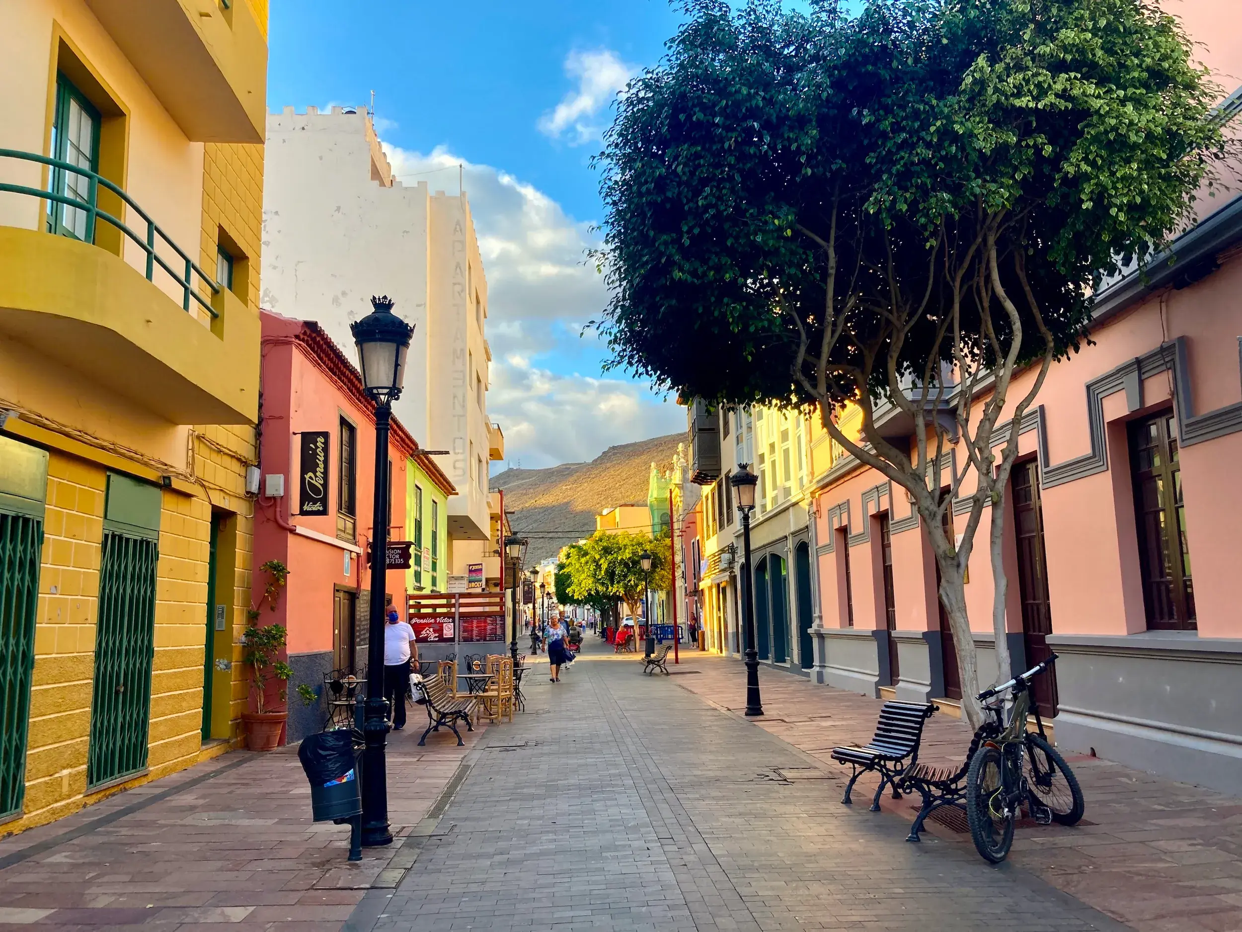 Sonnige Gasse mit bunten Kolonialhäusern und einem Baum in der Altstadt von Los Llanos de Aridane auf der Insel La Palma.