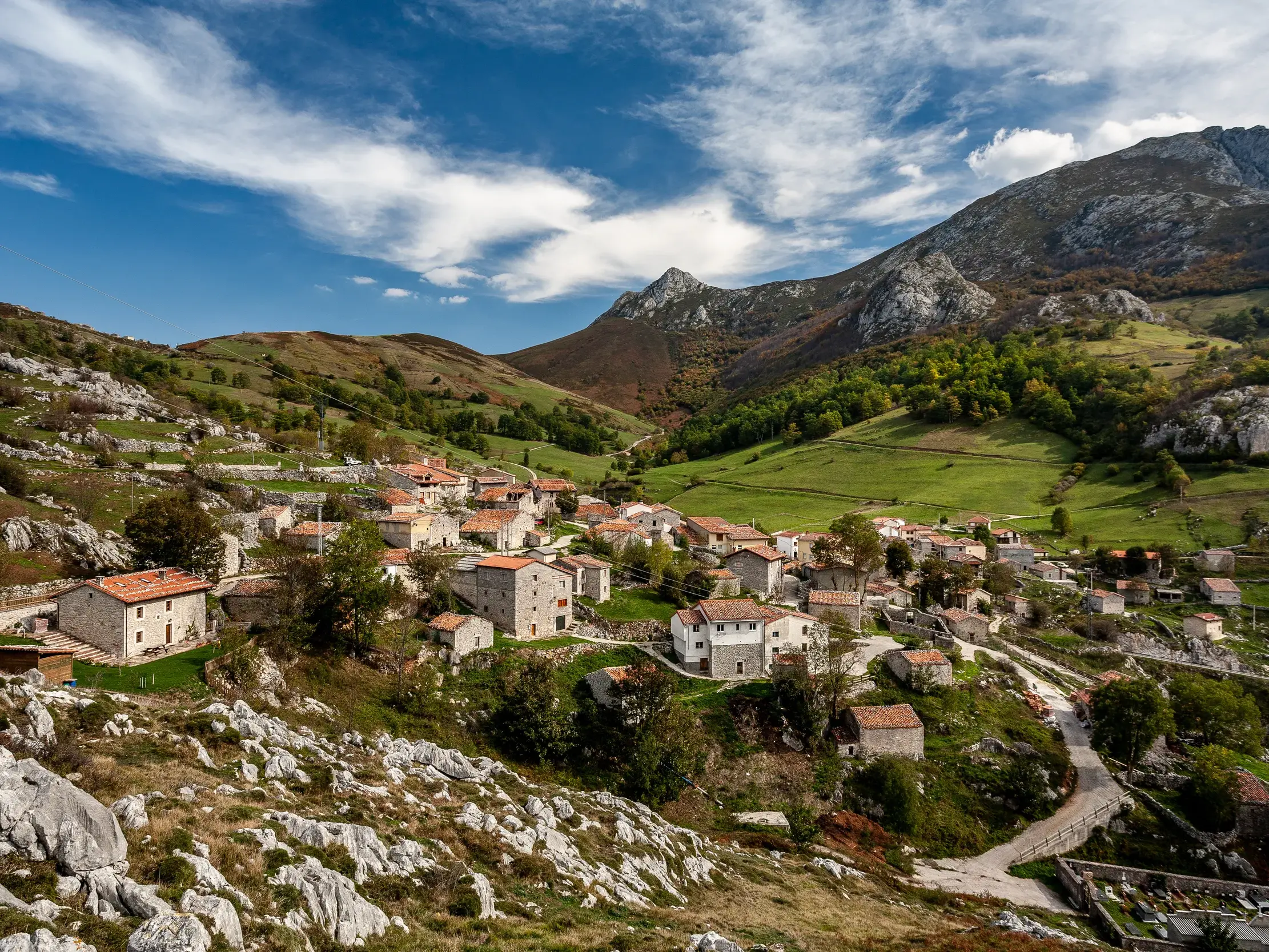 Traditionelle Steinhäuser des Bergdorfs Sotres umgeben von der malerischen Bergkulisse der Picos de Europa in Asturien.