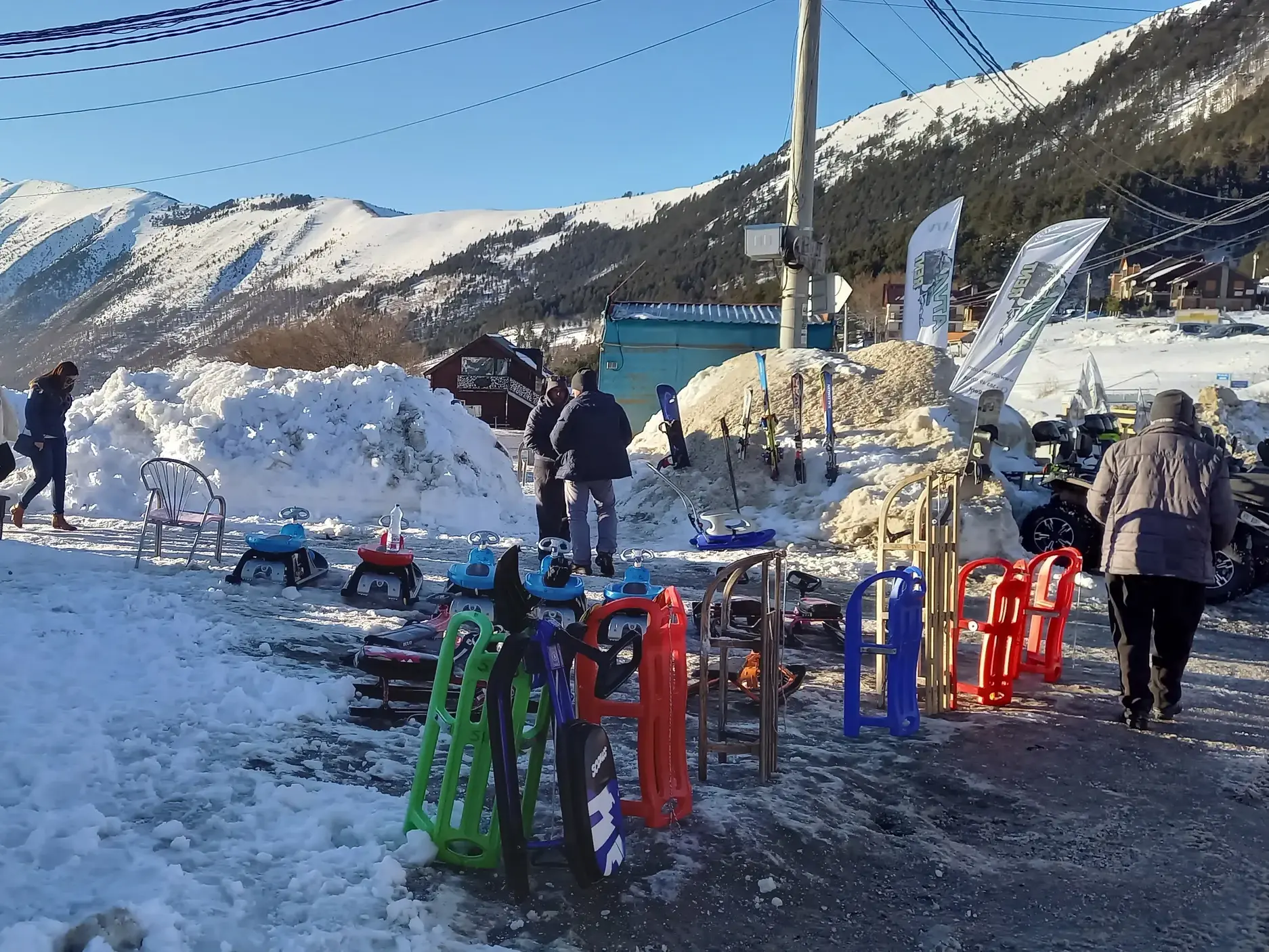 Lokaler Schlitten- und Skiverleih im Schnee im Wintersportort Brezovica im Kosovo vor einer Bergkulisse.