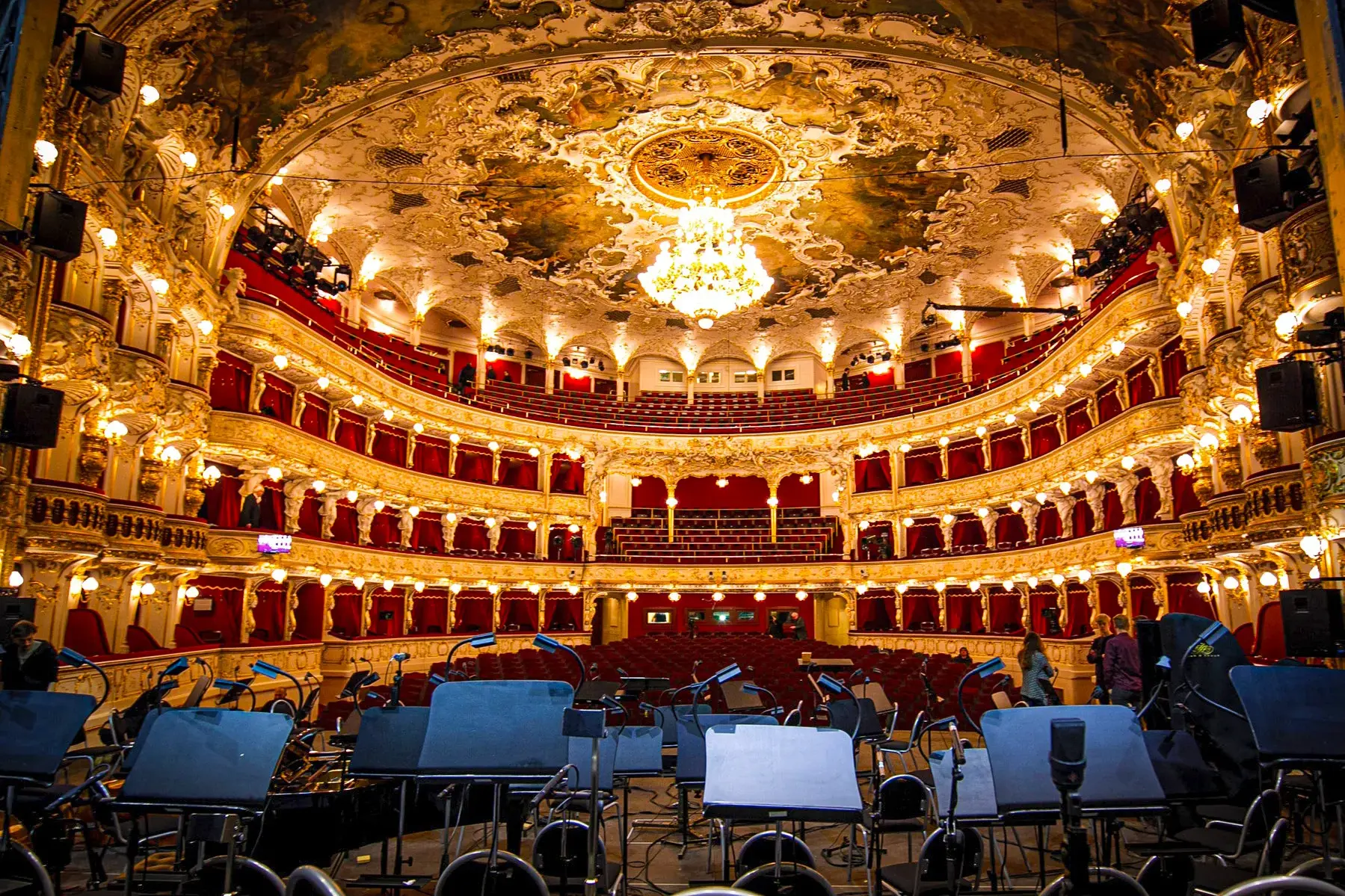 Prachtvoller Innenraum der Staatsoper in Prag mit festlich beleuchteten Logen und Deckenfresken