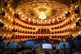 Prachtvoller Innenraum der Staatsoper in Prag mit festlich beleuchteten Logen und Deckenfresken