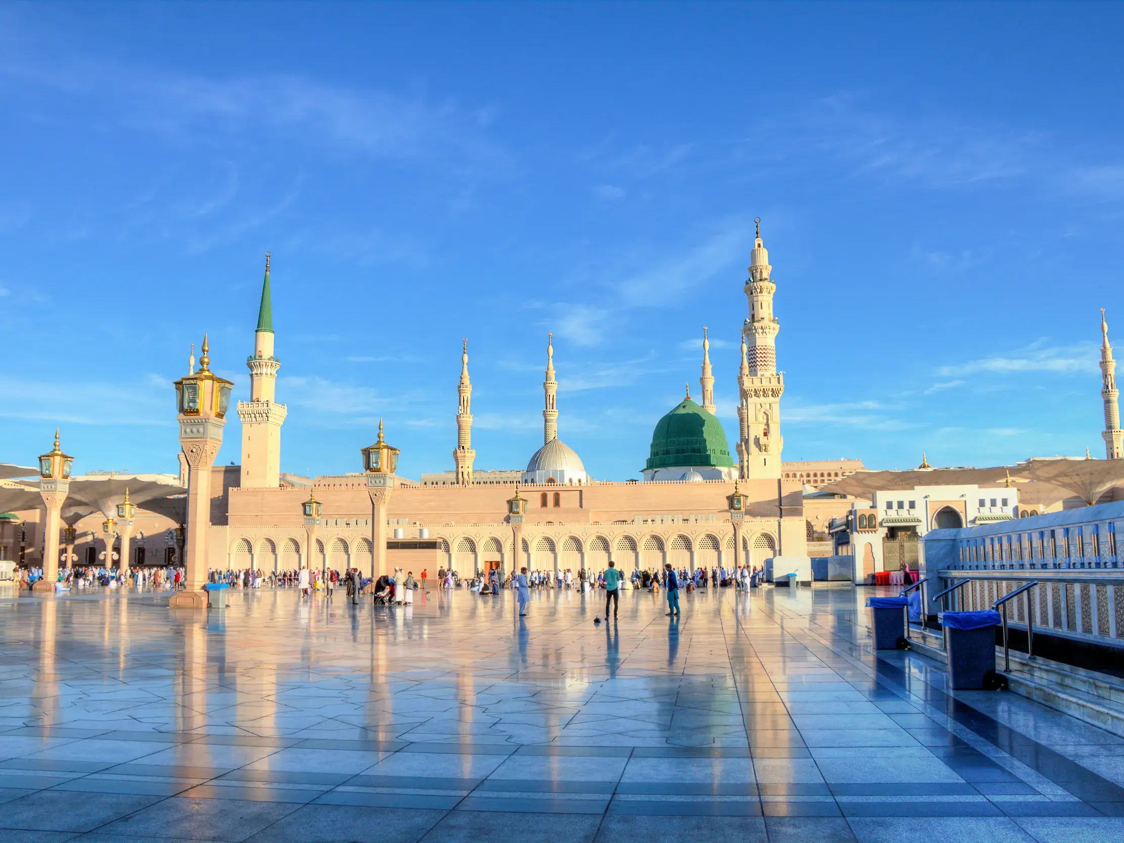Die Prophetenmoschee in Medina mit grüner Kuppel und Minaretten spiegelt sich im polierten Boden des weitläufigen Vorplatzes.