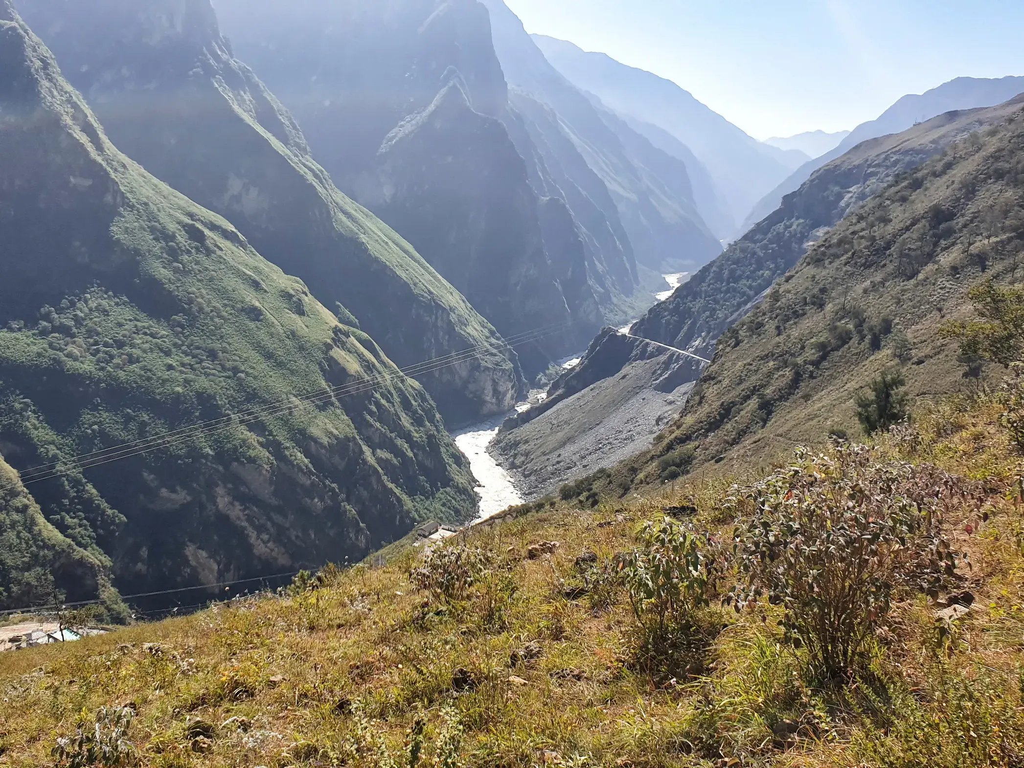 Weite Aussicht beim Trekking in China auf die imposante Tigersprungschlucht und den sich schlängelnden Jangtse Fluss.
