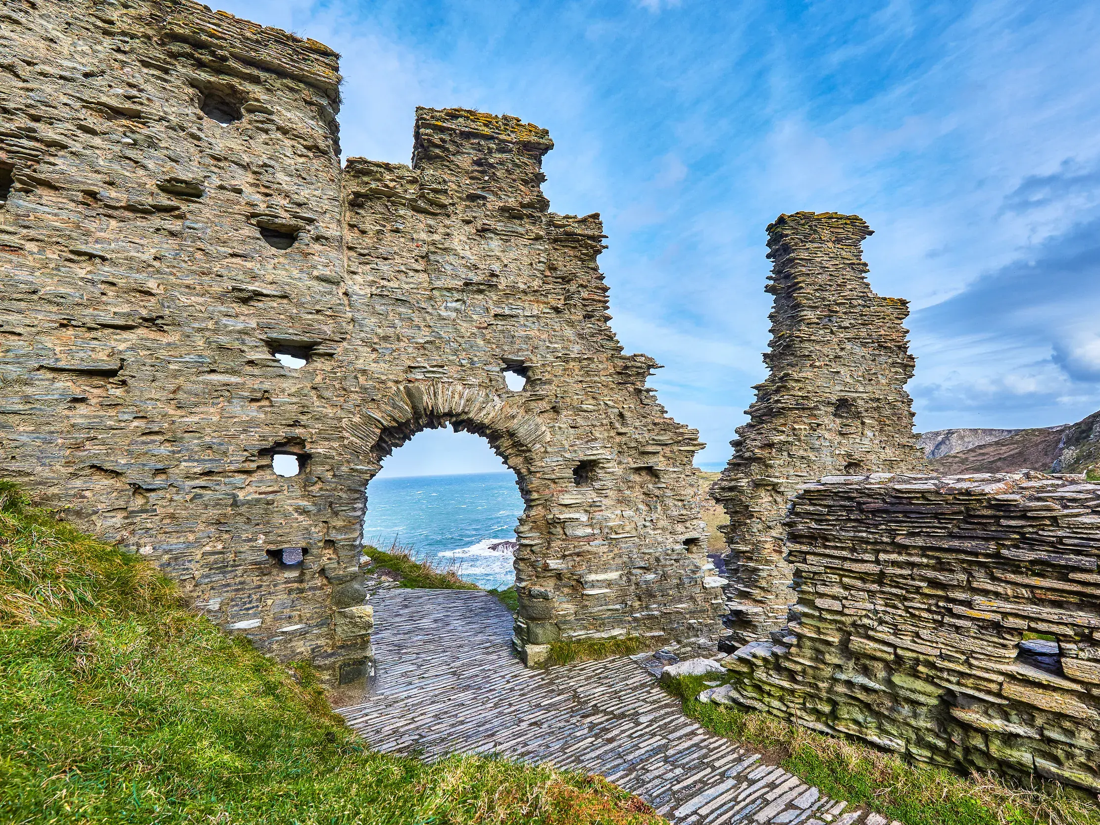 Die sagenumwobene Burgruine Tintagel Castle auf einem Felsen über der rauen Küste von Cornwall in Südengland.