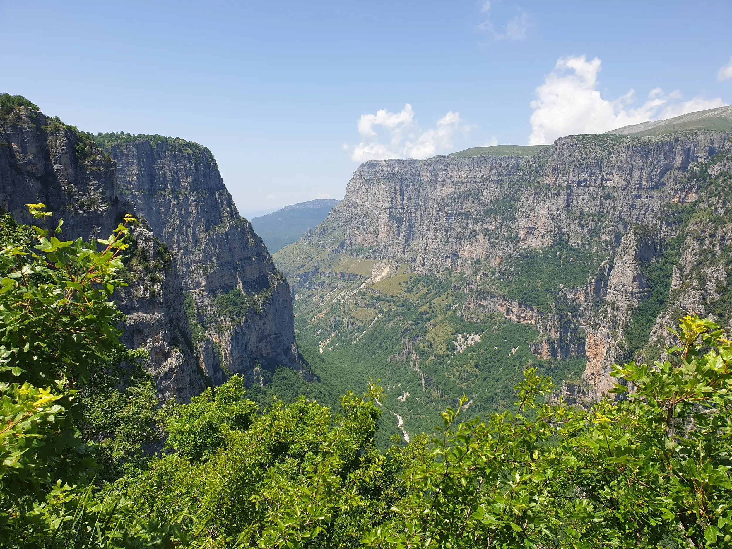 Atemberaubender Ausblick von einem Felsvorsprung auf die gewaltige Vikos-Schlucht mit steilen Felswänden in der Zagori-Region.