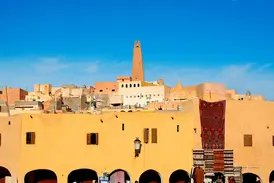 Die einzigartige Wüstenarchitektur der Oasenstadt Ghardaia (UNESCO-Welterbe) mit Minarett und buntem Markttreiben.