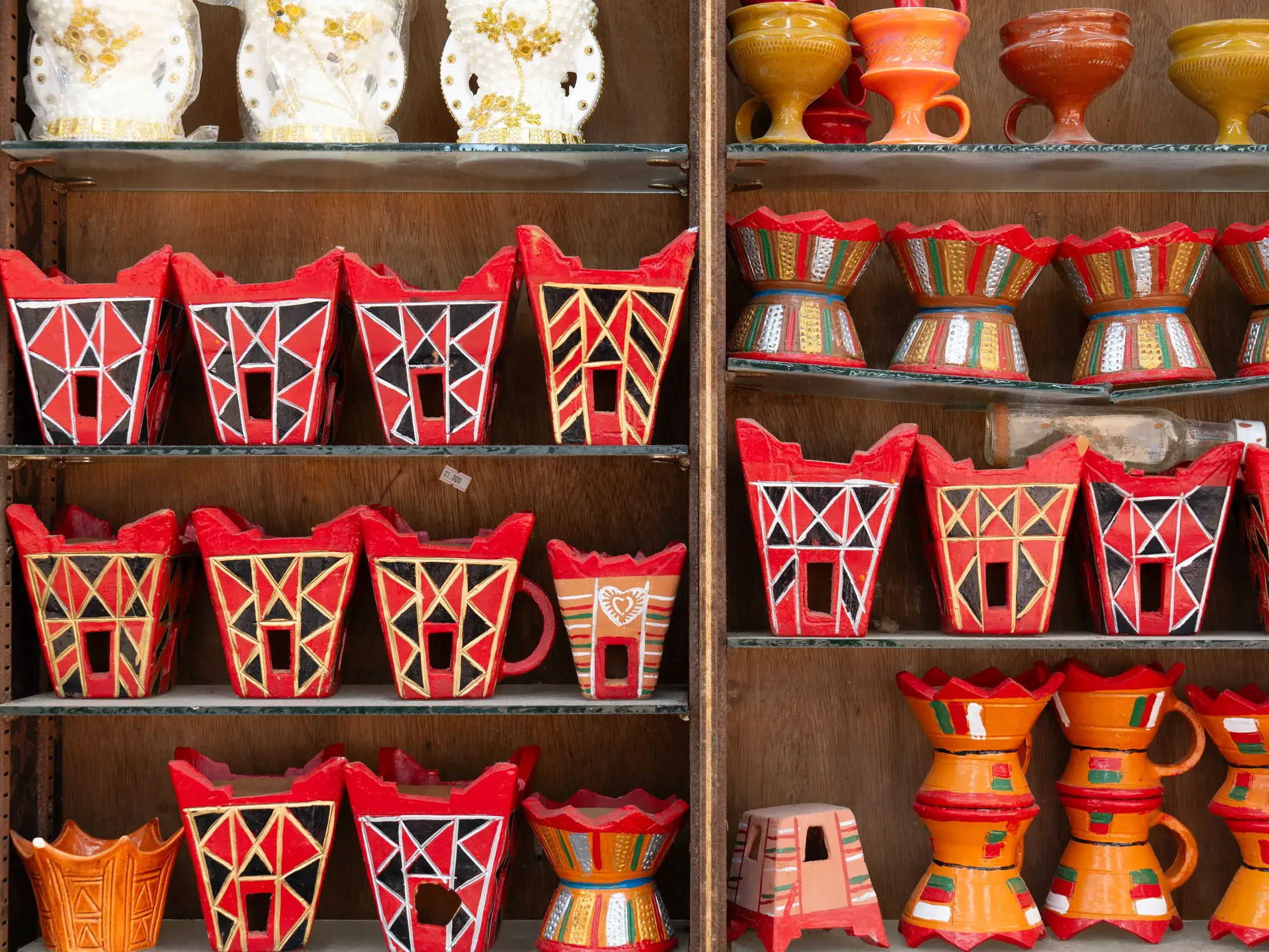 Traditionelle omanische Weihrauchbrenner und Töpferwaren, handbemalt mit geometrischen Mustern, in einem Regal im Souk.